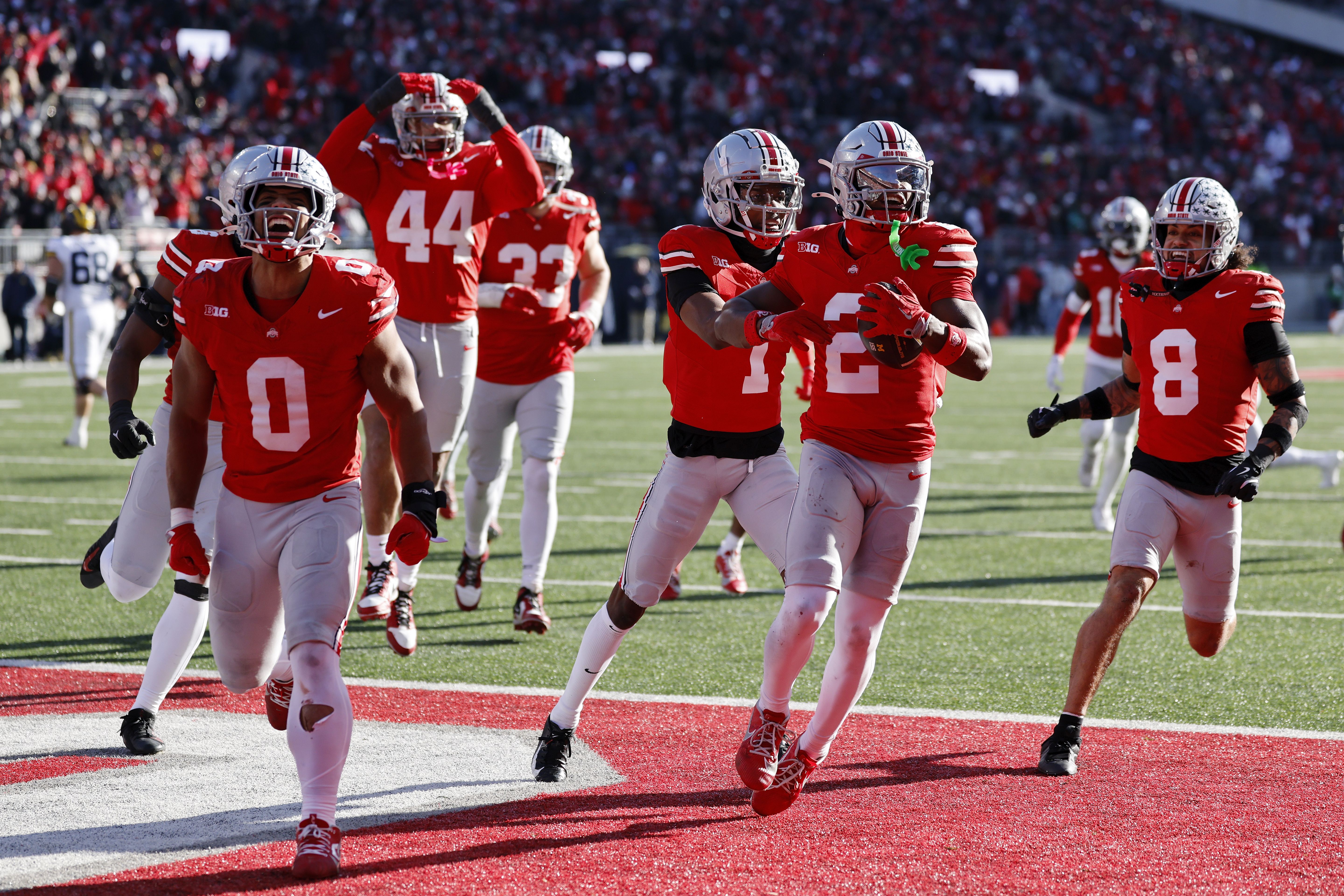 OSU football players celebrate in the endzone after scoring a touchdown. 