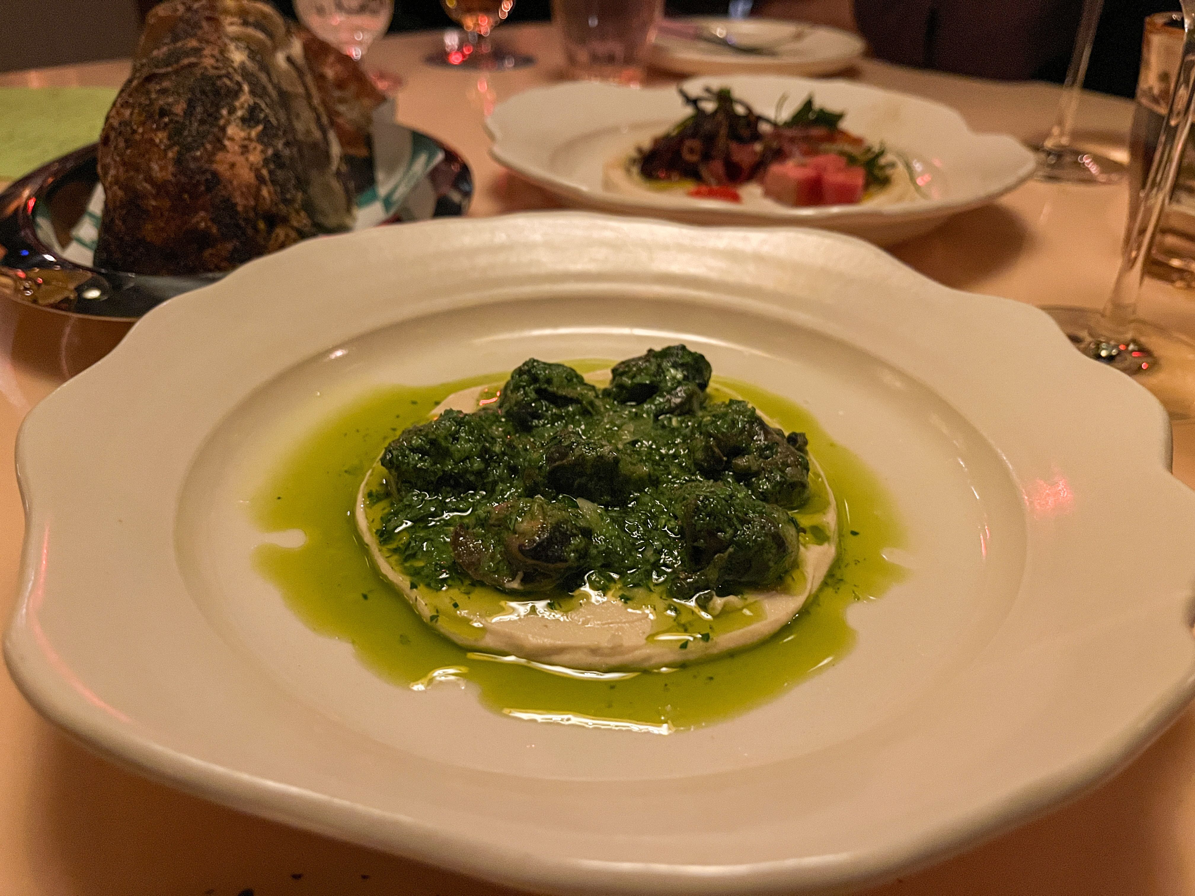 Escargot hummus on a white dinner plate.