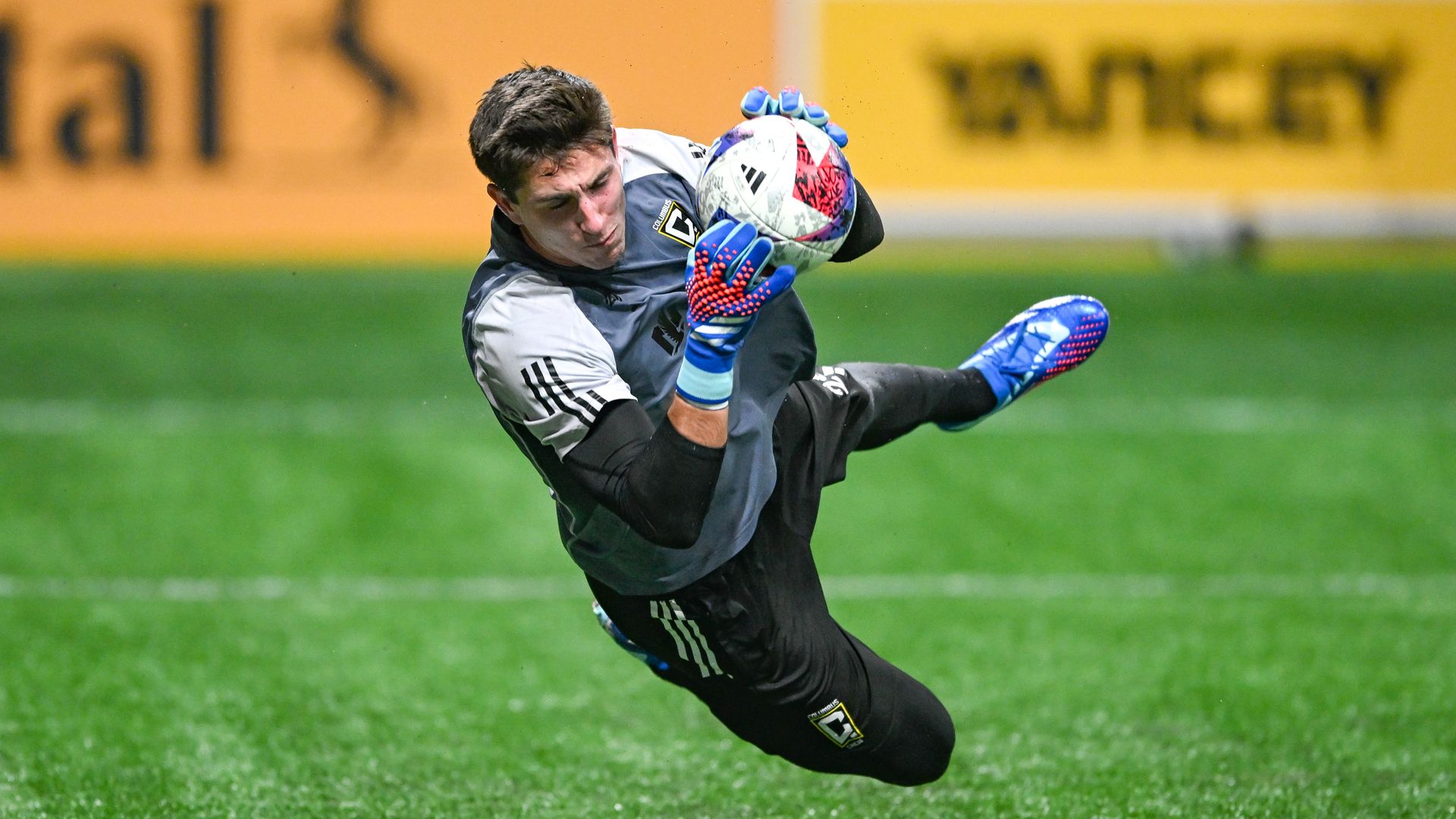 Patrick Schulte dives to catch a soccer ball. 
