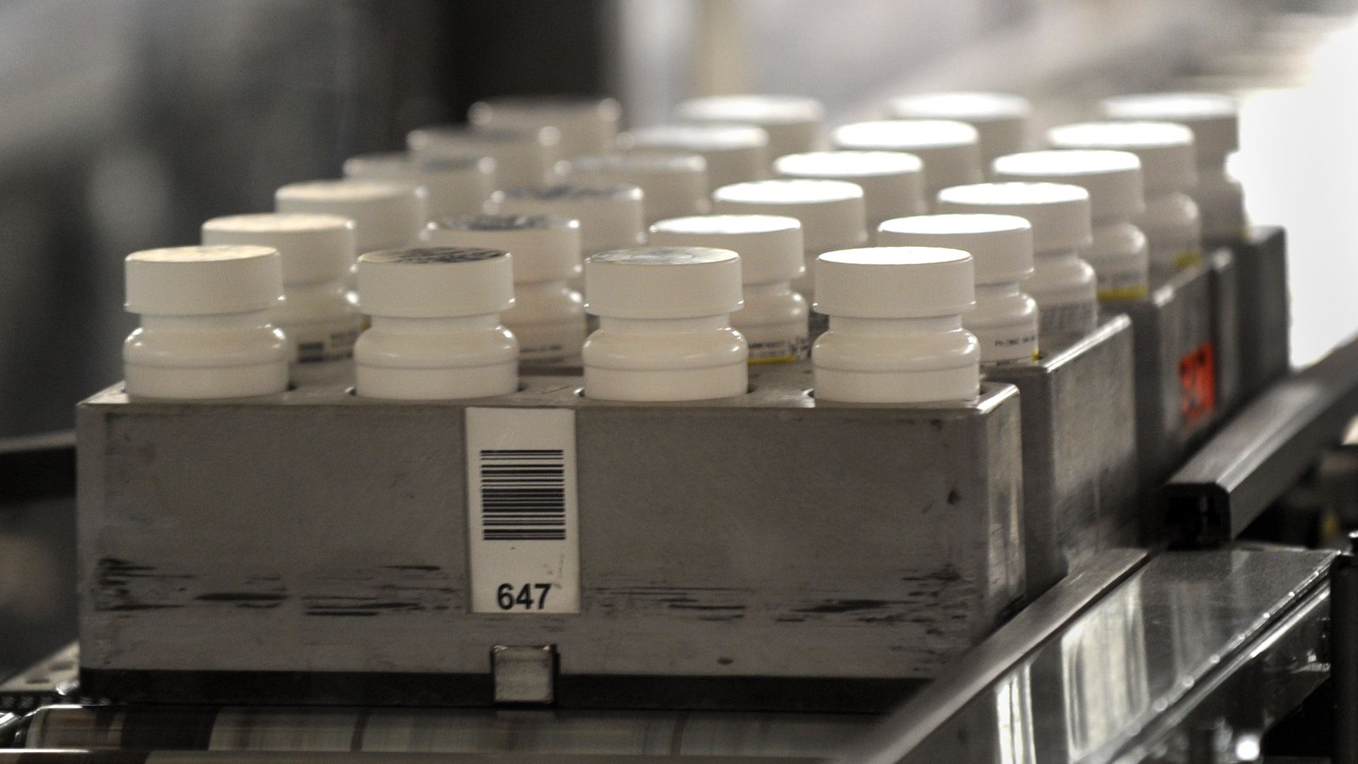 Bottles of prescription pills go through an automated packaging machine.