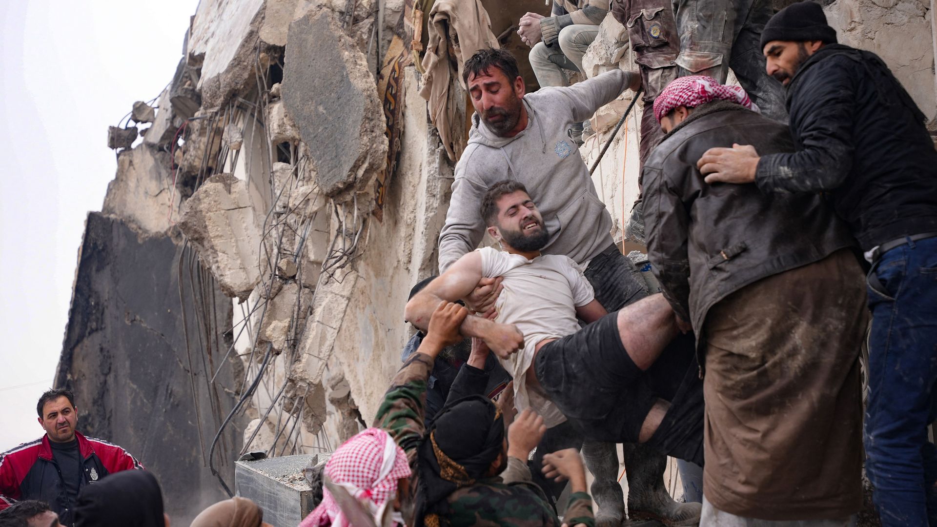 Residents retrieve an injured man from the rubble of a collapsed building following an earthquake in the town of Jandaris, Syria, on February 6, 2023. 