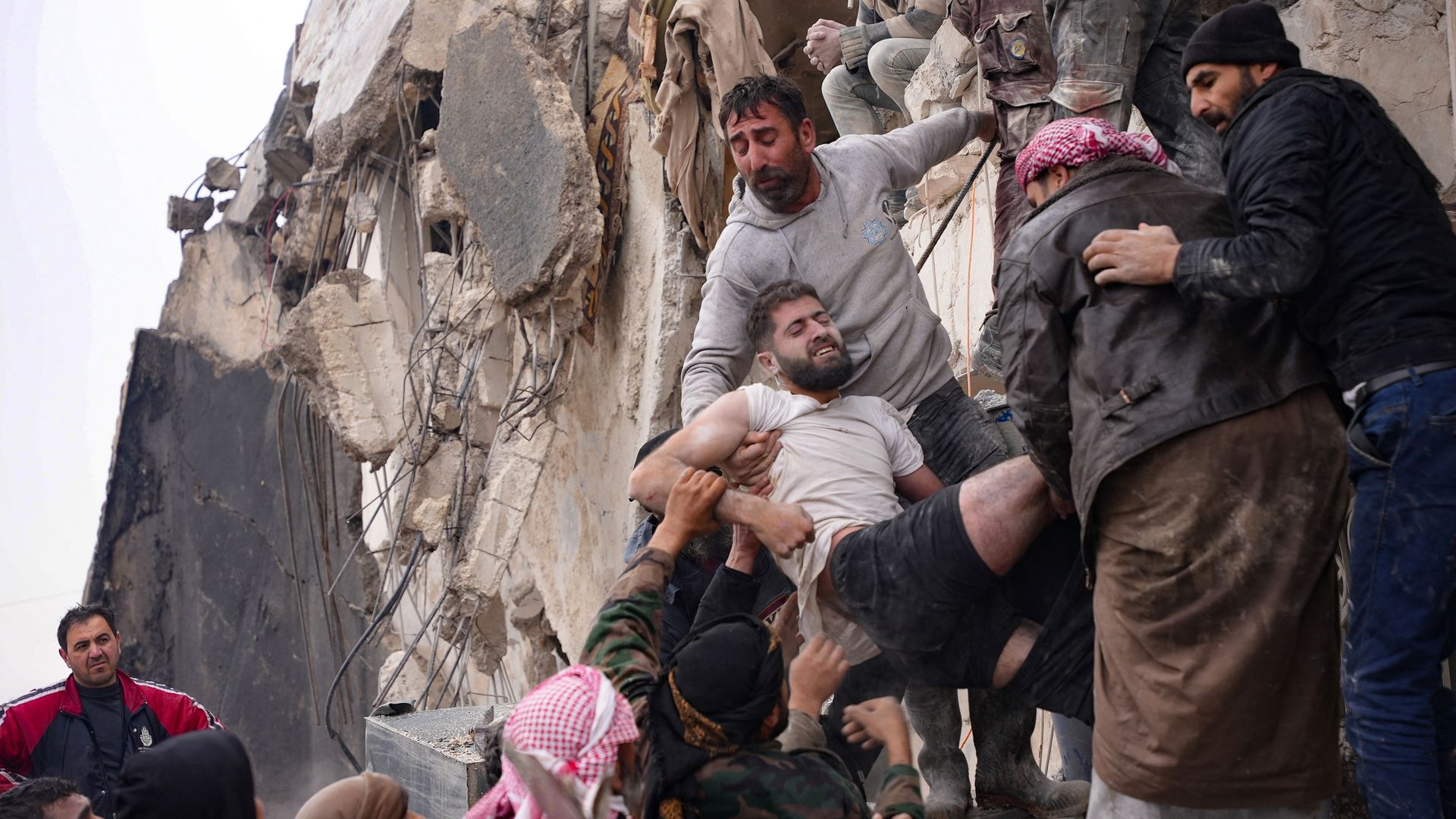 Residents retrieve an injured man from the rubble of a collapsed building following an earthquake in the town of Jandaris, Syria, on February 6, 2023.