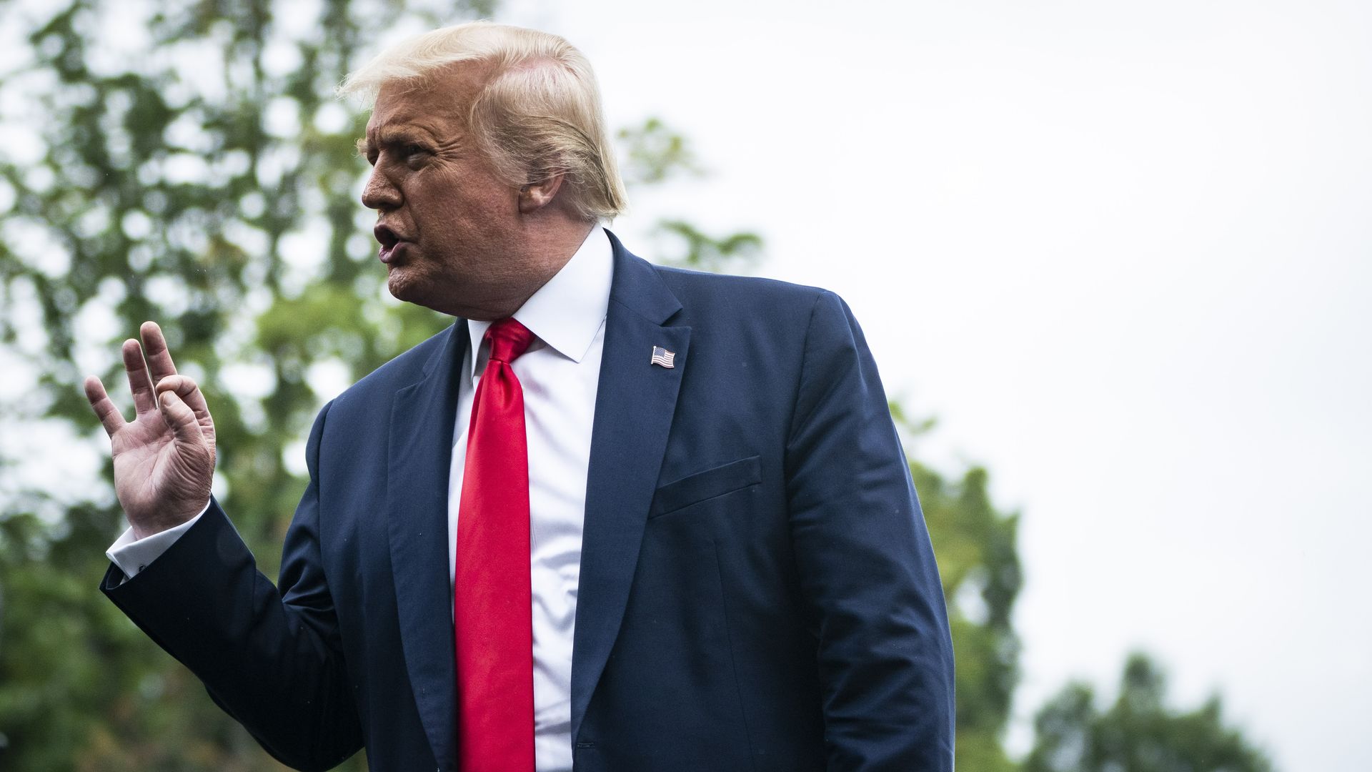 Trump in a suit talks to press