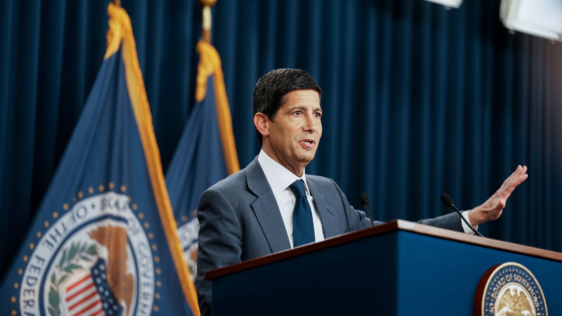 Federal Reserve chairman Kevin Warsh standing and gesturing at the podium during an October 2026 press conference.