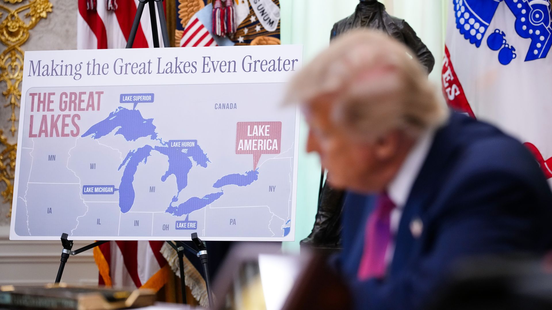 A map labeling Lake Ontario as "Lake America" is displayed with the title "Making the Great Lakes Even Greater" while President Trump sits in the foreground,