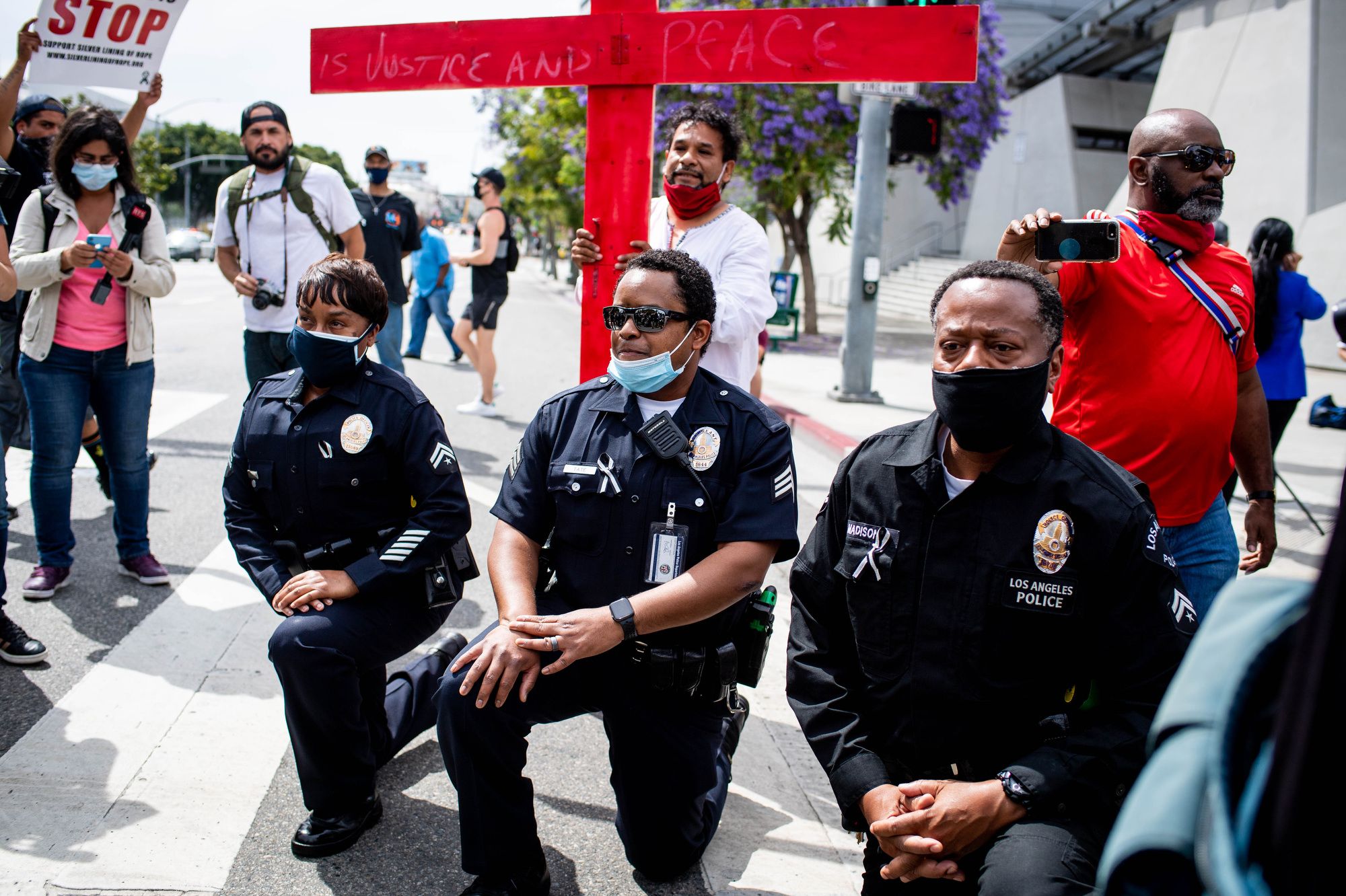 LAPD officers take a knee with clergy and marchers at LAPD Headquarters during a demonstration 