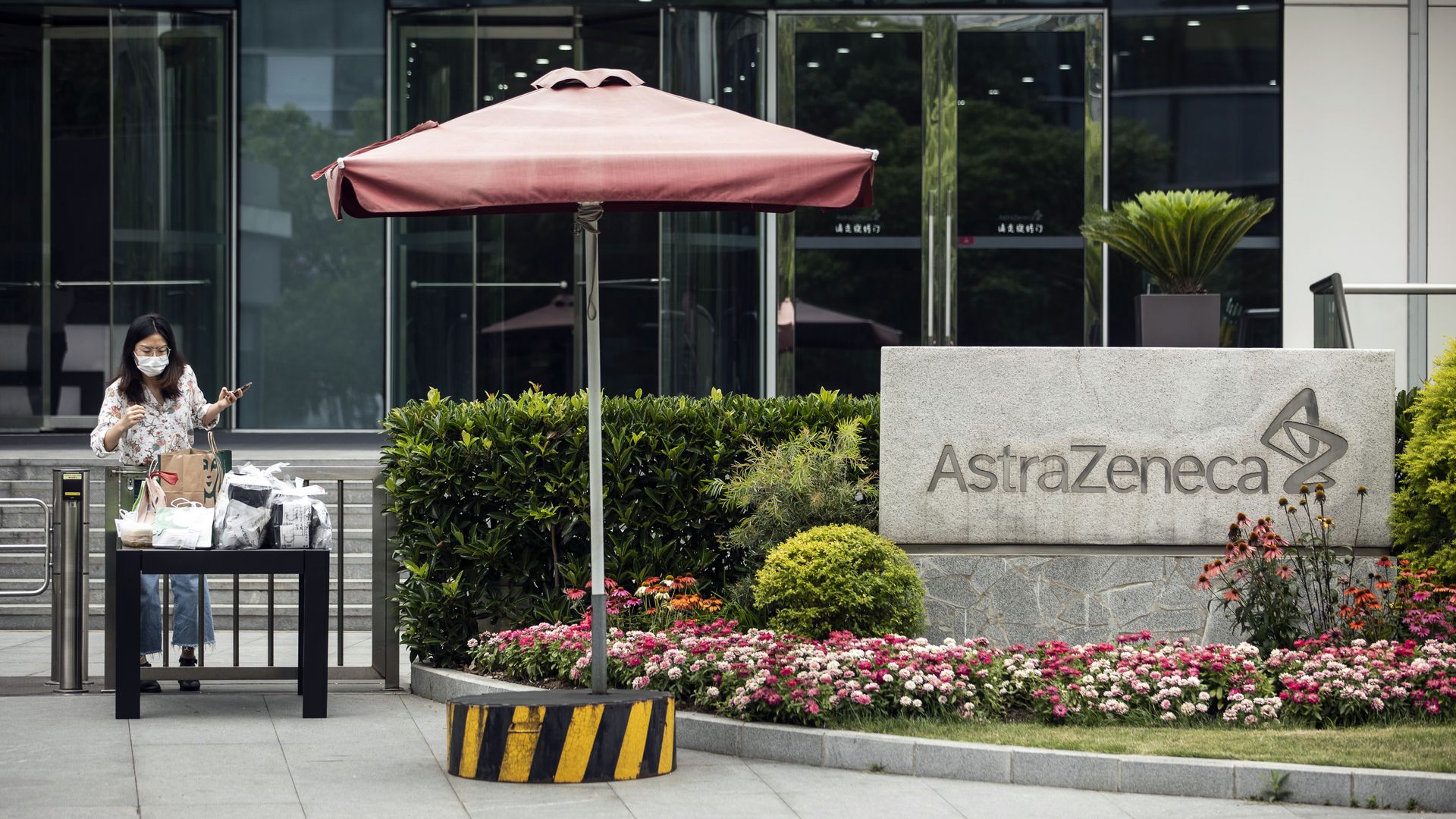 An employee wearing a protective mask collects a lunch delivery from a table outside an AstraZeneca Plc research and development facility in Shanghai, China, on Monday, June 8, 2020. 