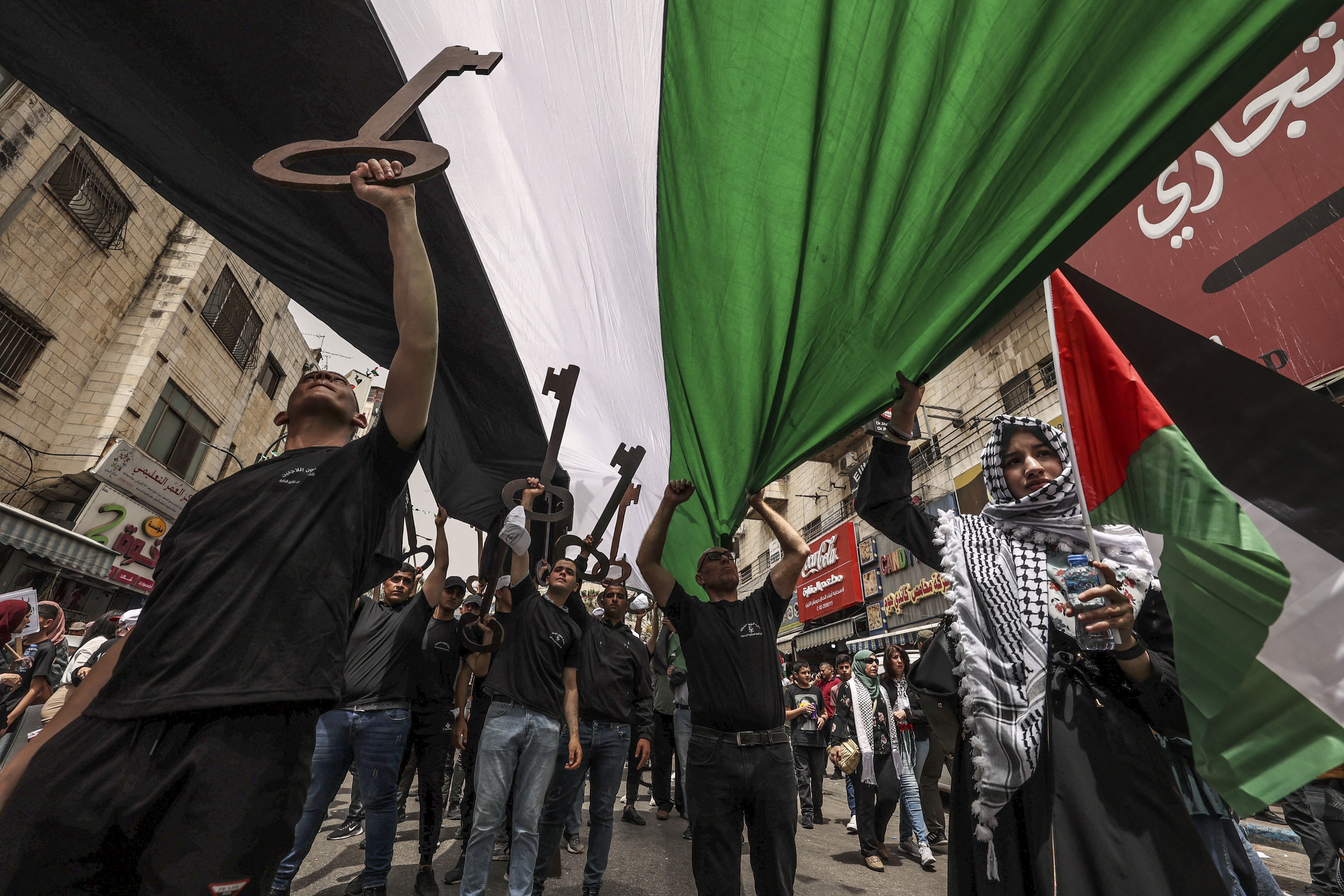 Palestinian wave national flags and carry giant mock keys (a widely used symbol of the Nakba, as many Palestinians kept the keys to their homes when they were forced into exile in 1948)