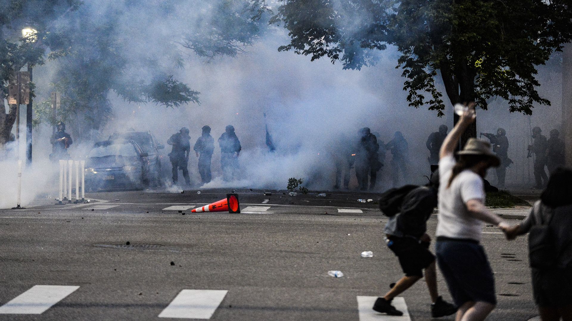 Police officers stand behind a wall of tear gas as they attempt to disperse people marching along Colfax Avenue during the fourth consecutive day of protests in the aftermath of the death of George Floyd on May 31, 2020 in Denver. Photo: Michael Ciaglo/Getty Images