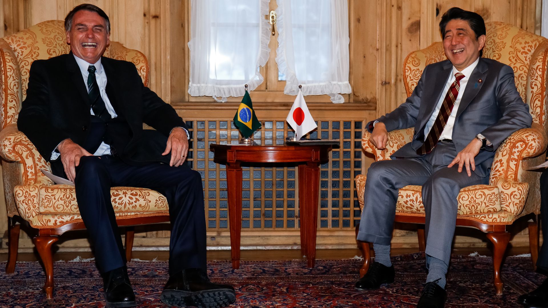 Brazilian President Jair Bolsonaro laughs with Japanese Prime Minister Shinzo Abe at the World Economic Forum in Davos