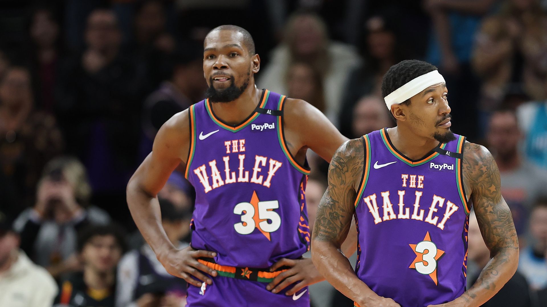 Kevin Durant and Bradley Beal stand on the basketball court during a break in a game. 