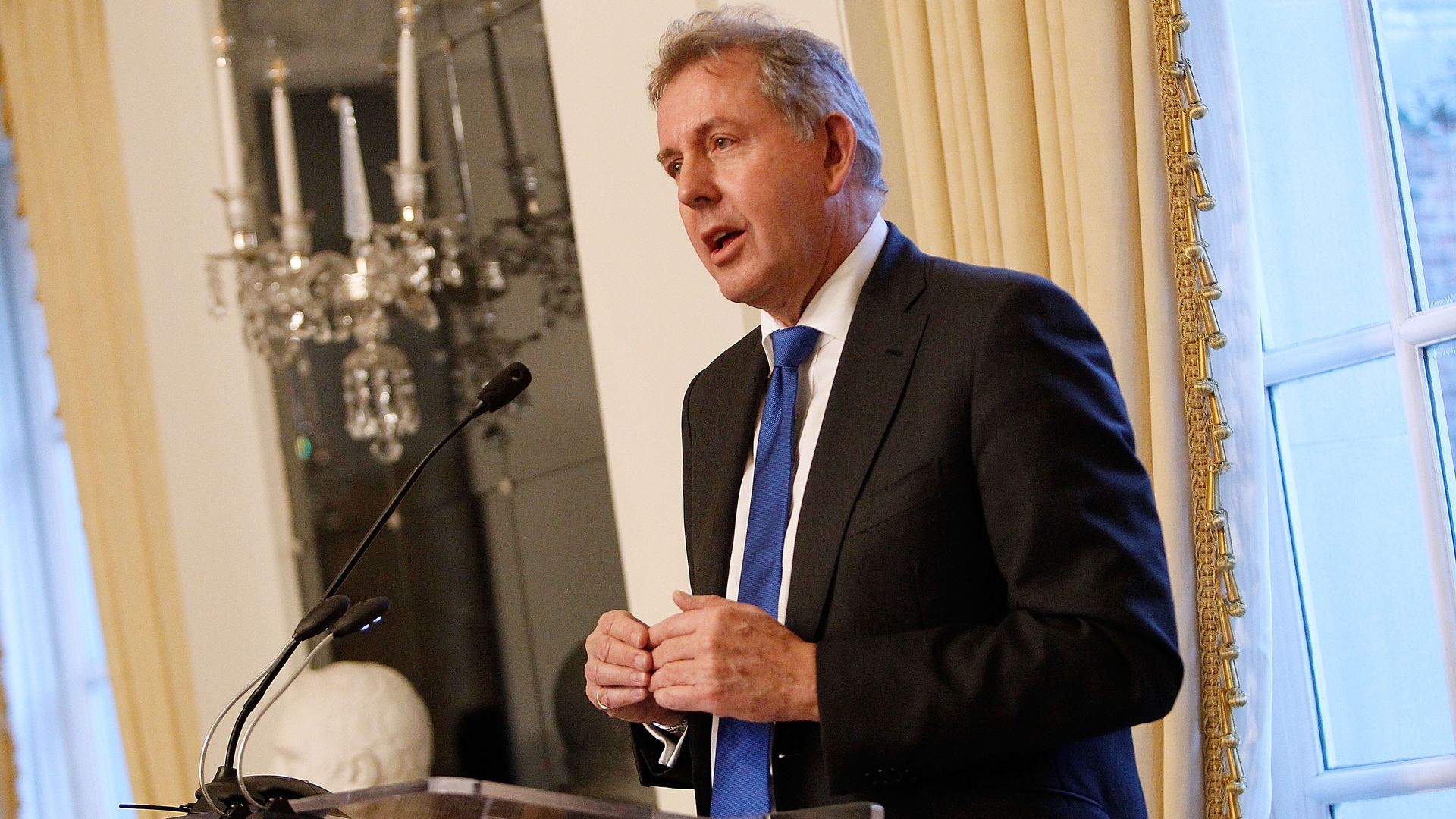 In this image, Darroch stands behind a podium and speaks.