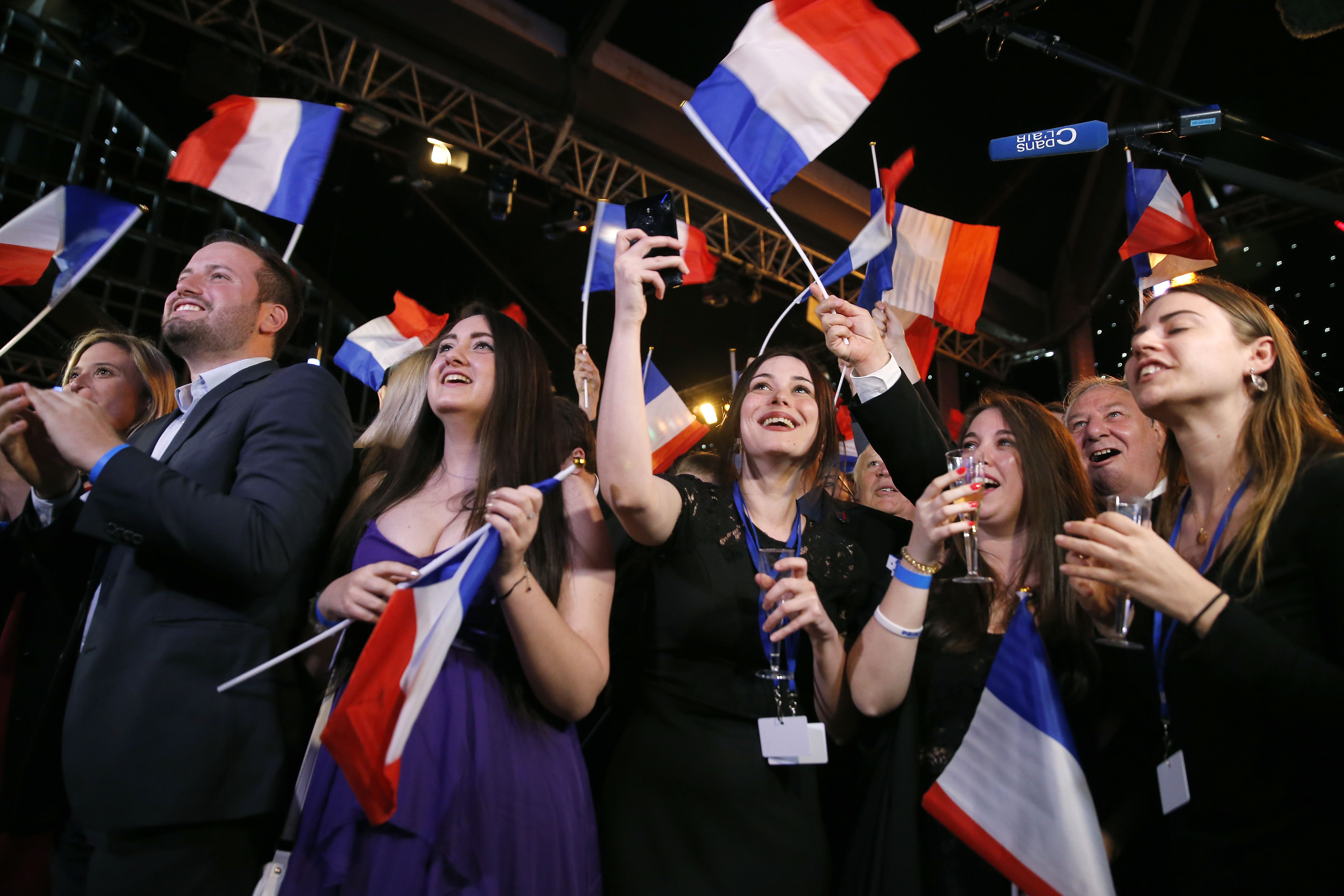 Supporters of French far-Right National Rally political party react after the projections for the results of the European Parliament elections on May 26, 2019 in Paris, France. 