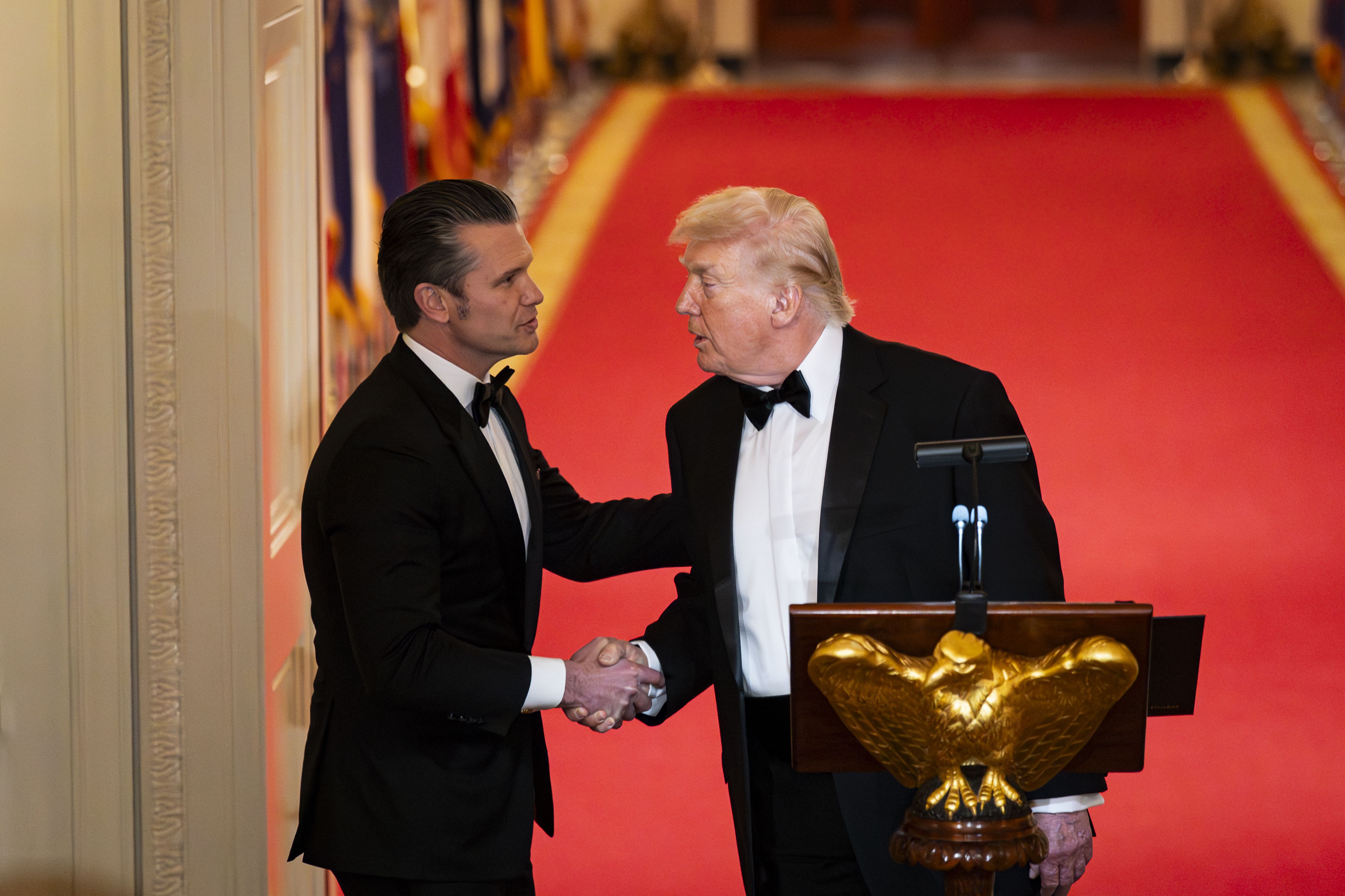 President Trump shakes hands with Defense Secretary Pete Hegseth during the National Governors Association dinner in the East Room on Saturday.
