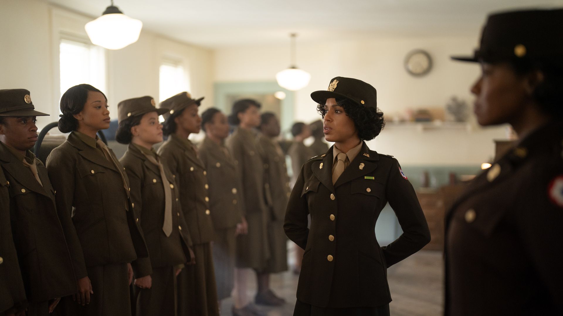 Kerry Washington wears an army uniform while examining a row of uniformed women. 