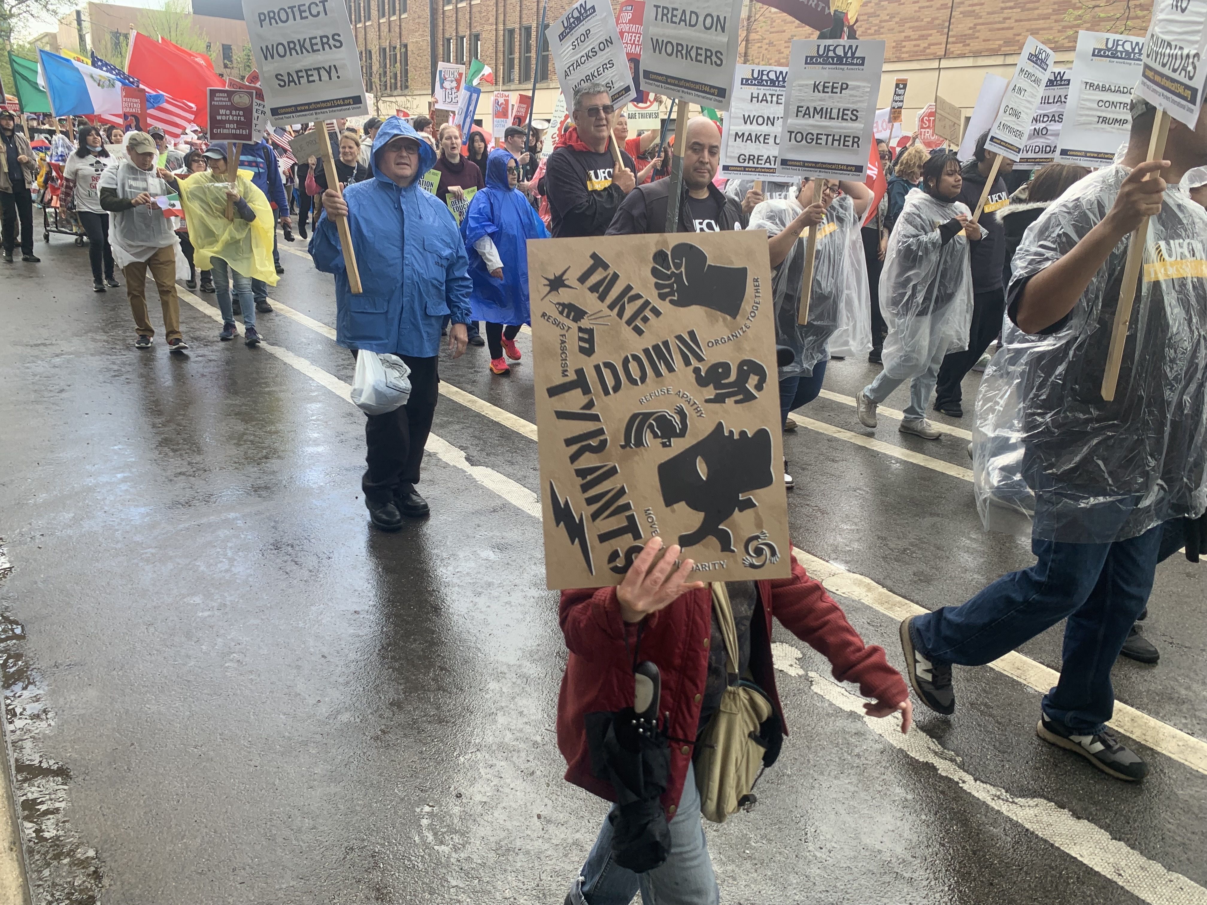 Photo of a protester holding a sign saying "take down tyrants" 