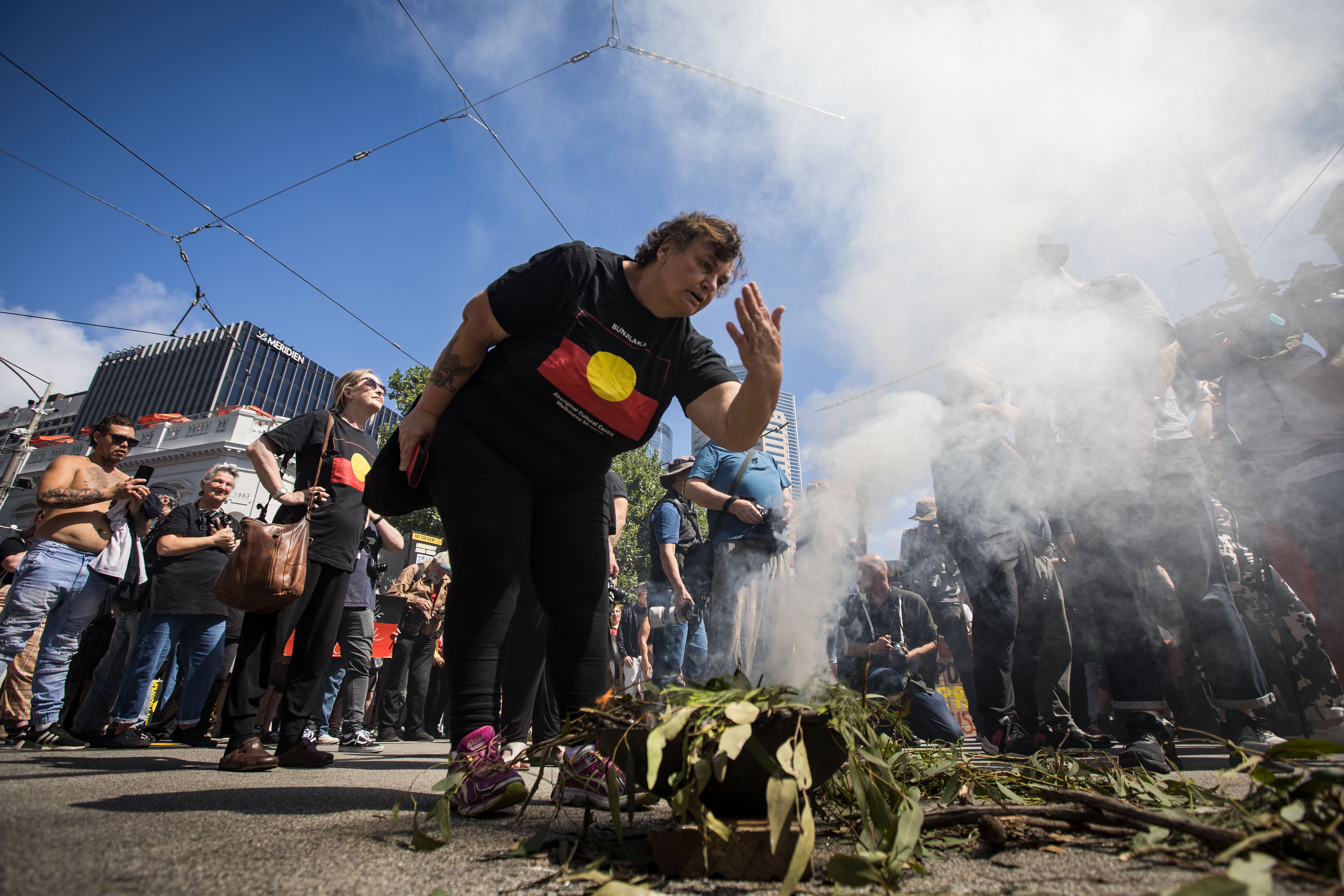 People take part in a smoking ceremony during the Invasion Day rally on January 26, 2023 in Melbourne, Australia. 