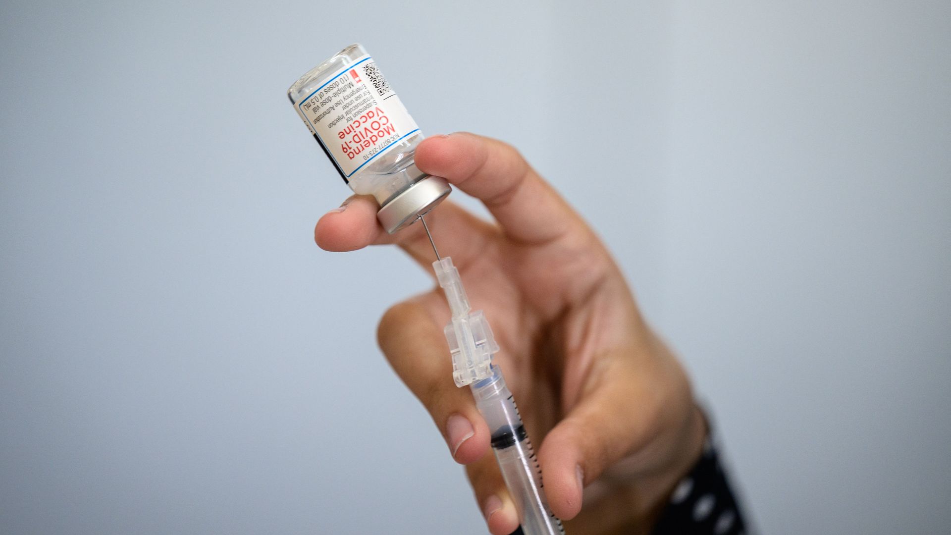 Photo of a hand holding a vaccine shot