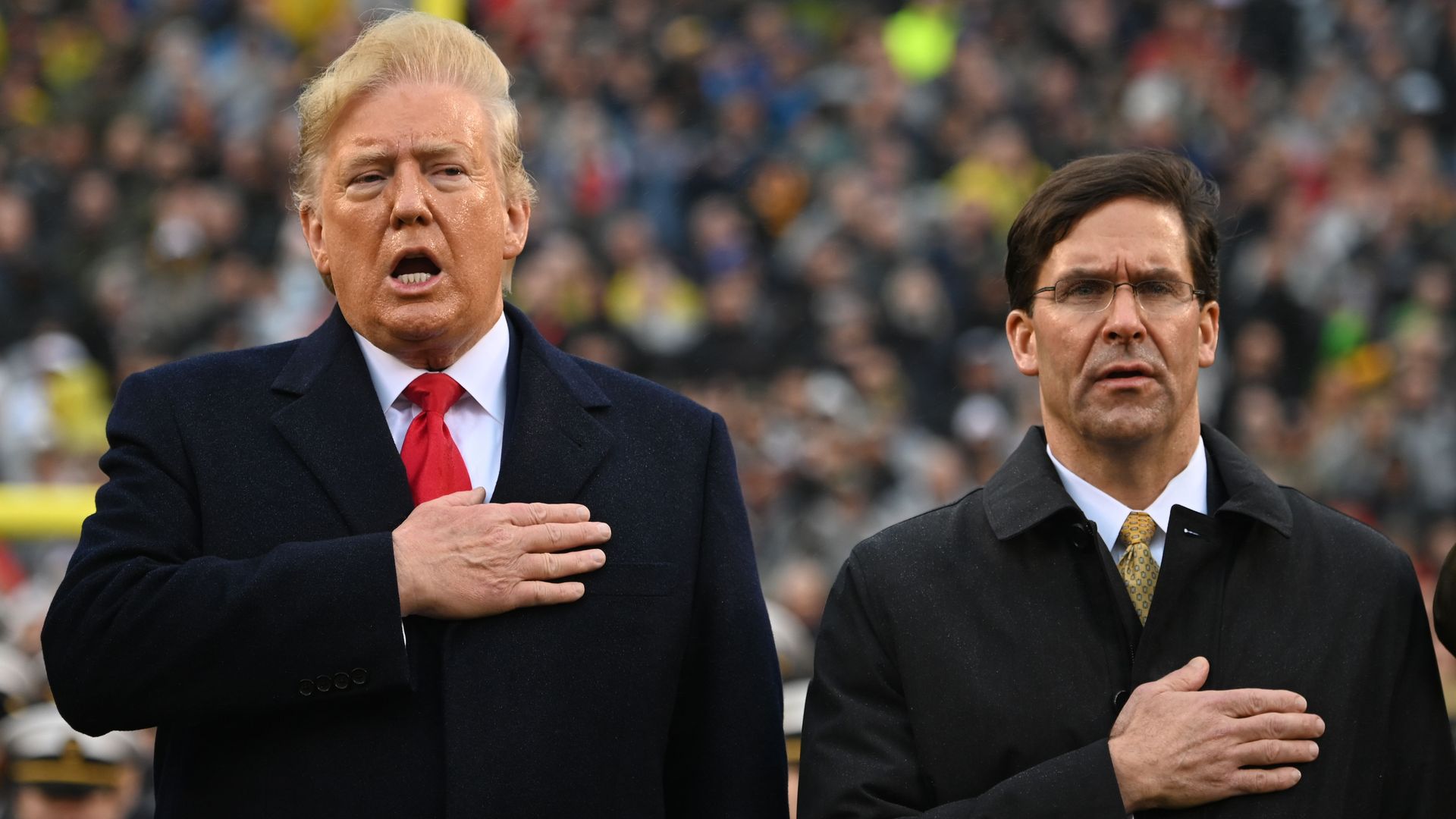Trump and Esper with their hands over their hearts. 