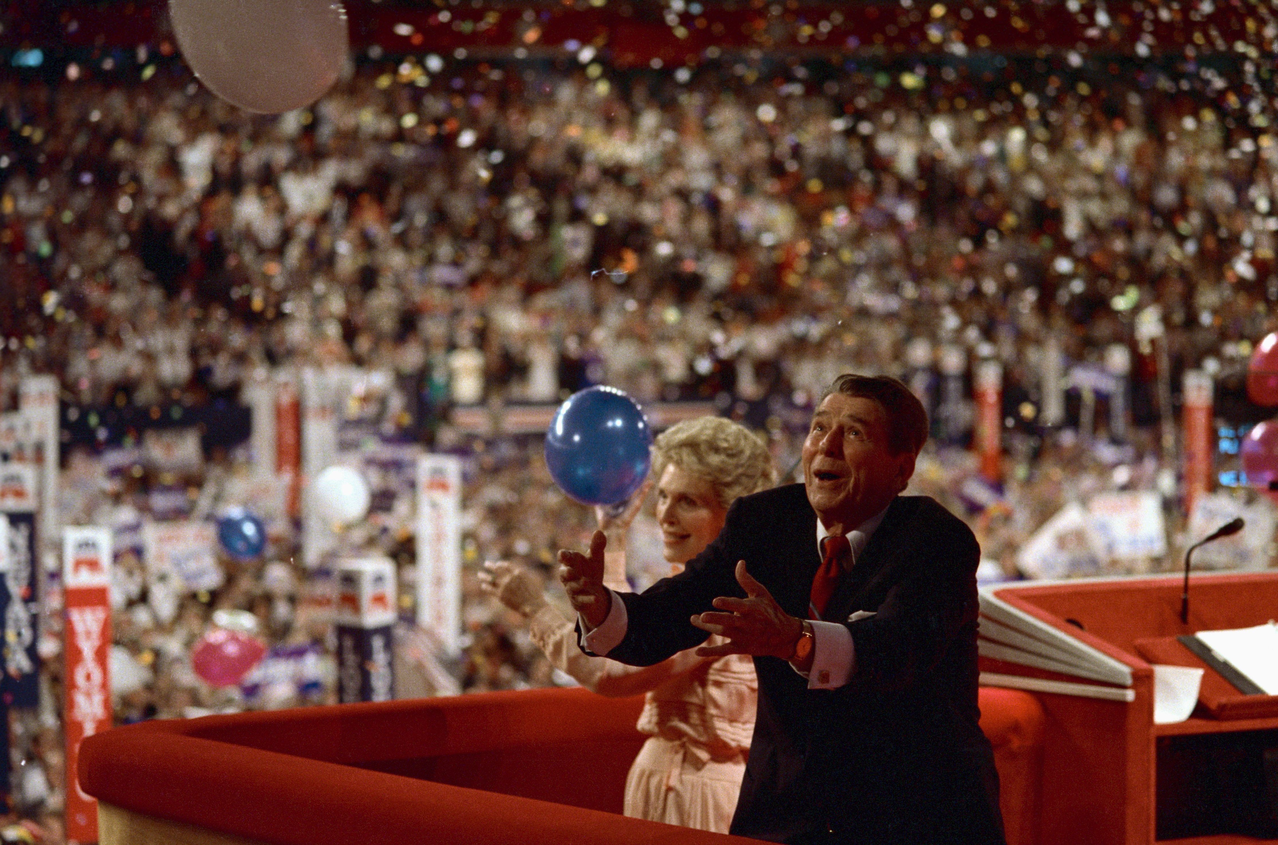 Photo shows President and Mrs. Reagan enjoy the balloons as they fall on the delegates at the conclusion of Reagan's speech to the Republican National Convention.