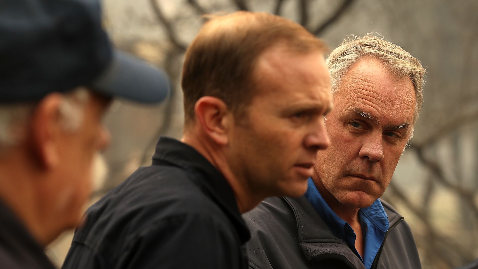 Ryan Zinke and two other men talking.