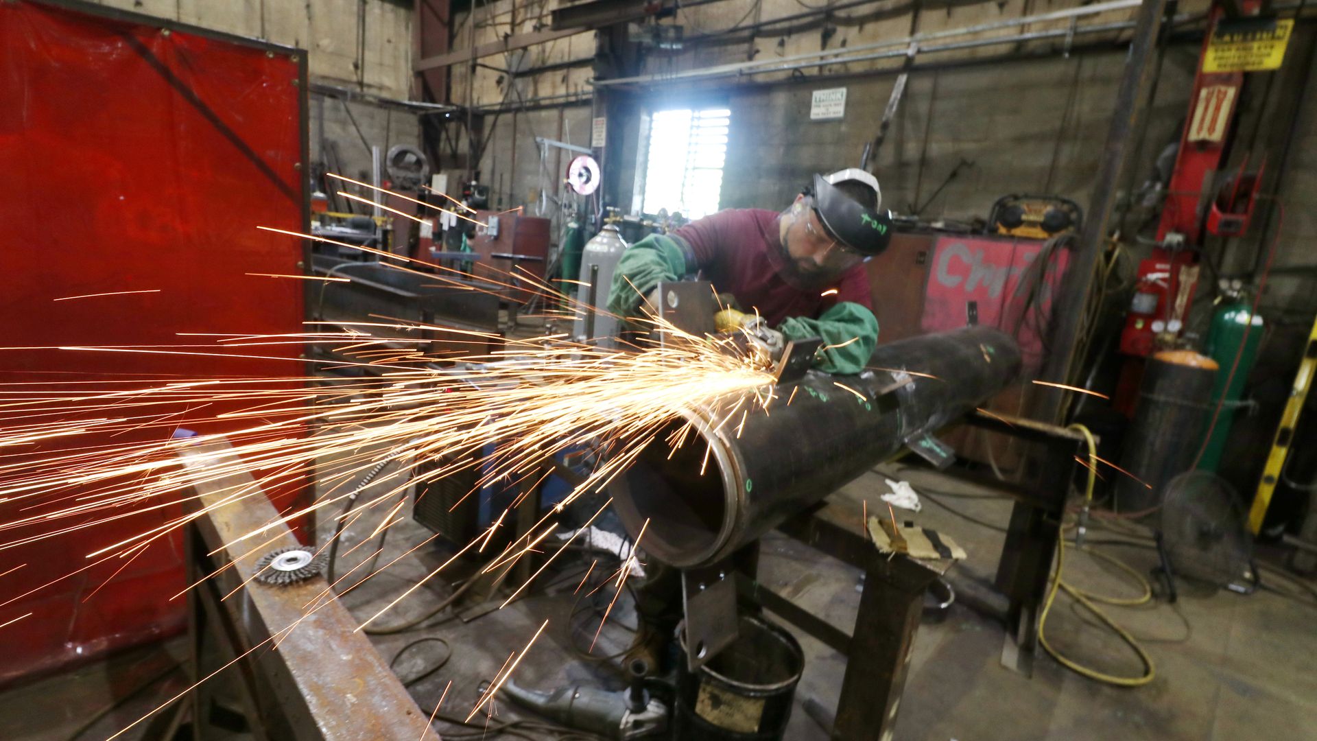 A man using an angle grinder on steel.