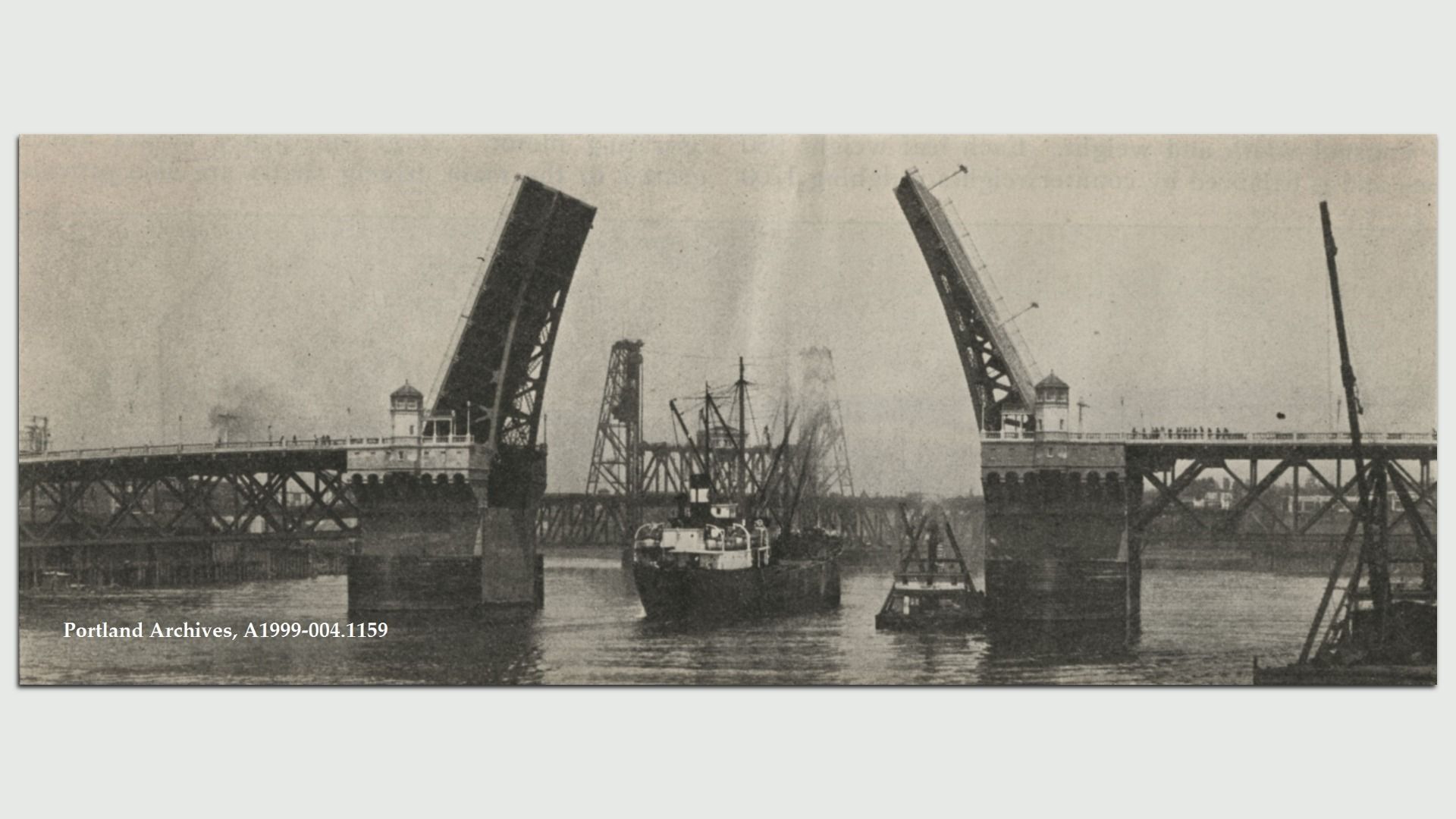 Black-and-white historic photo of a drawbridge with two raised spans over a harbor, ships nearby, and a control tower on each side; watermark reads Portland Archives.