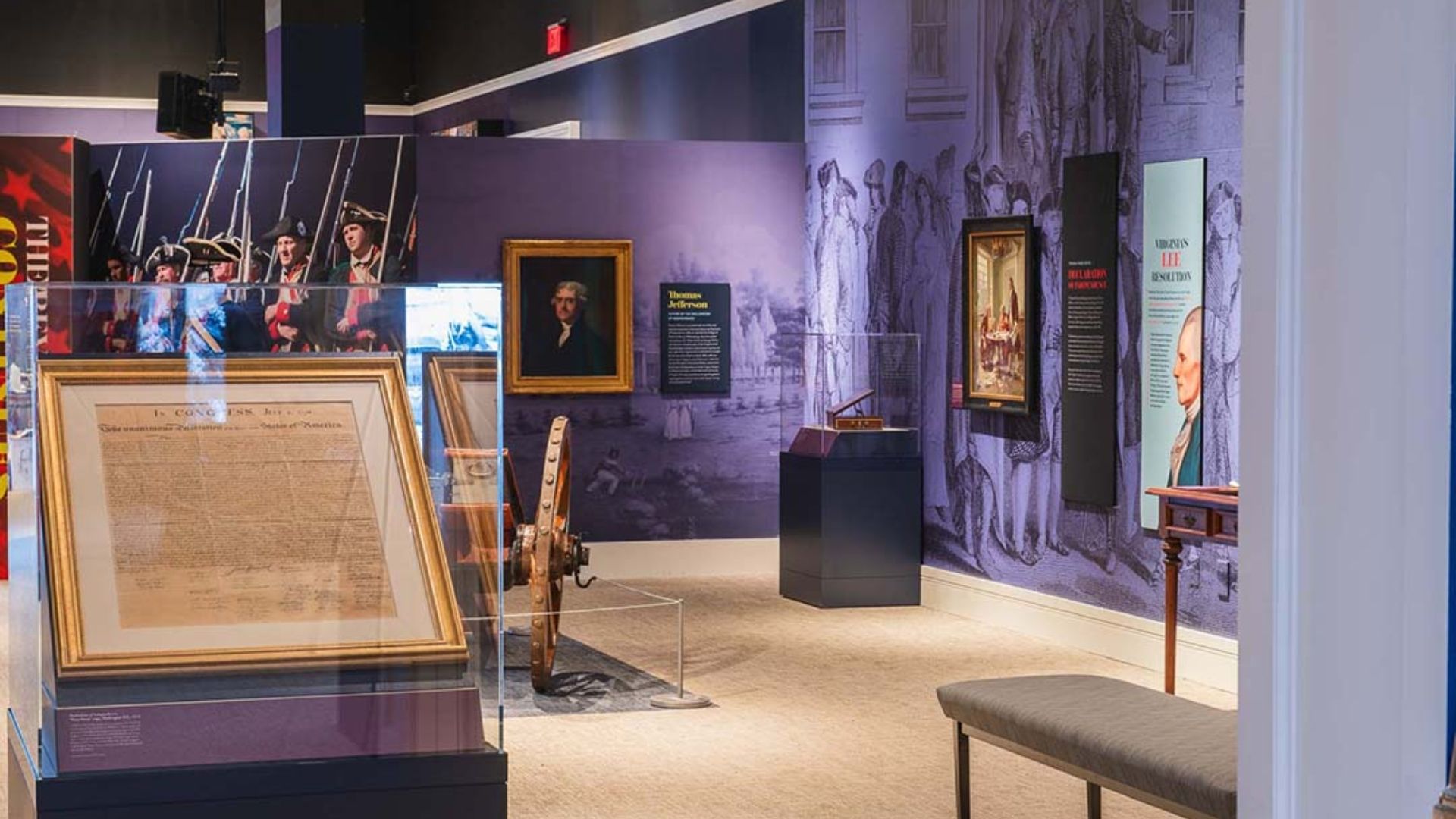 Museum exhibit showcasing American Revolution artifacts, including historical documents, portraits, and interpretive displays.