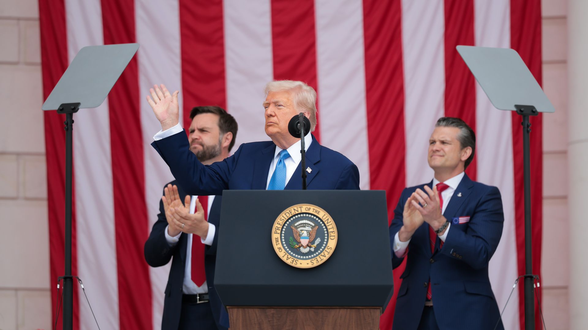 Trump waves as JD Vance and Pete Hegseth clap behind him.