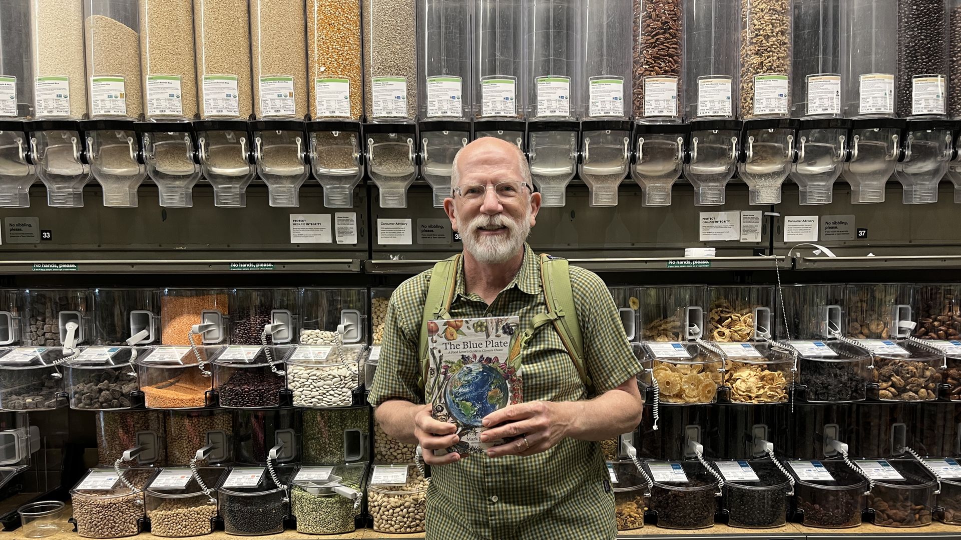 Man in front of bulk containers. 