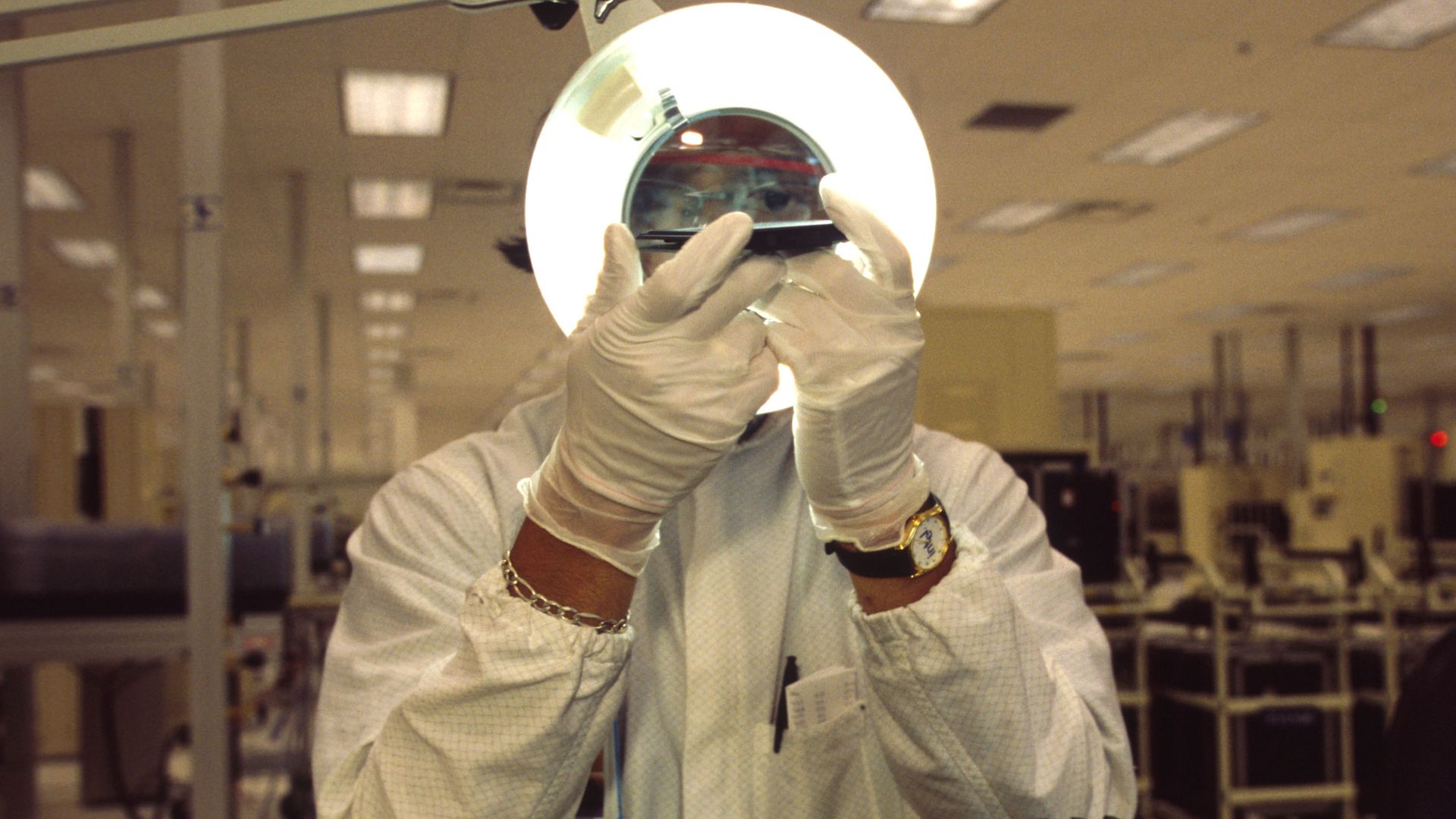 Photo of a man holding up a computer chip to a light