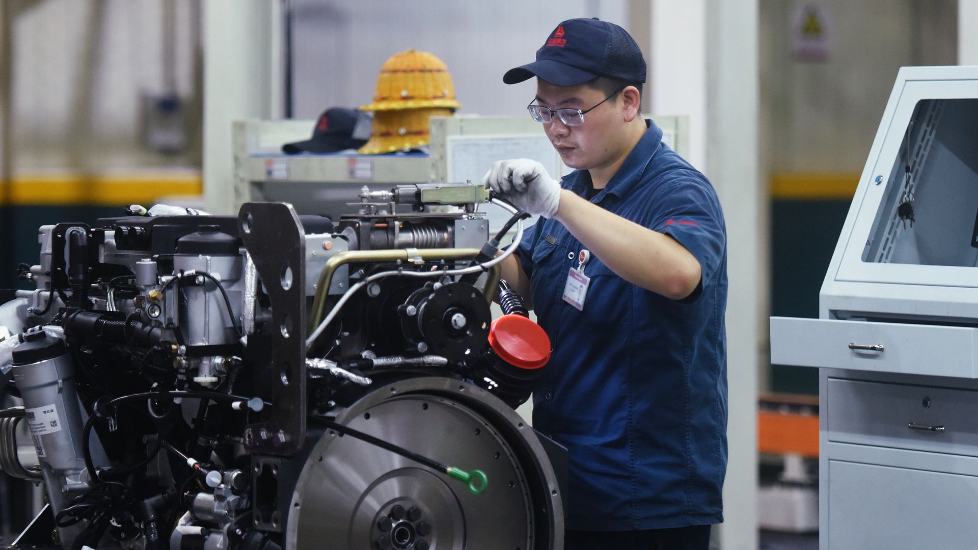 A worker assembles heavy truck engines at sinotruk Hangzhou Engine Company's production workshop in Xiaoshan Robot Town in Hangzhou, East China's Zhejiang Province, Oct. 18, 2021.