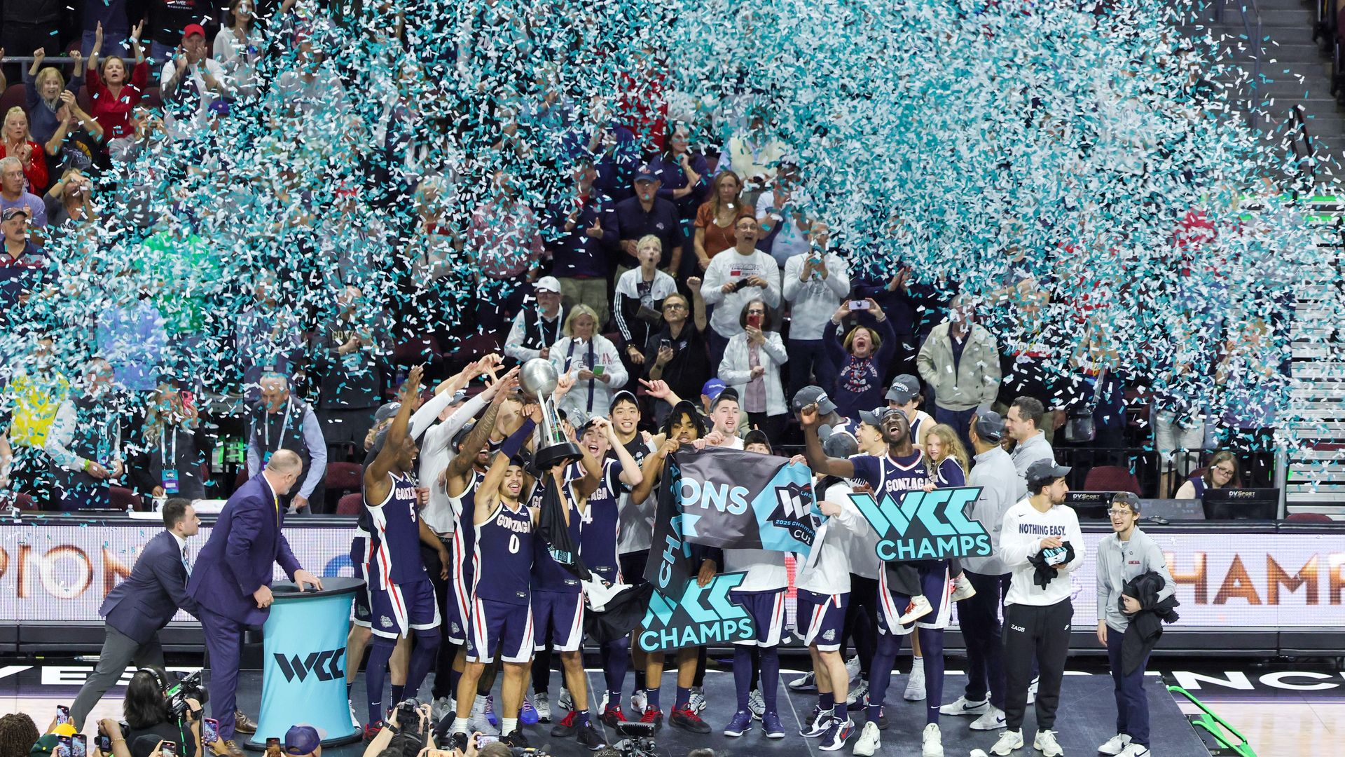 The Gonzaga men's basketball team celebrates winning the WCC with blue confetti flying around them