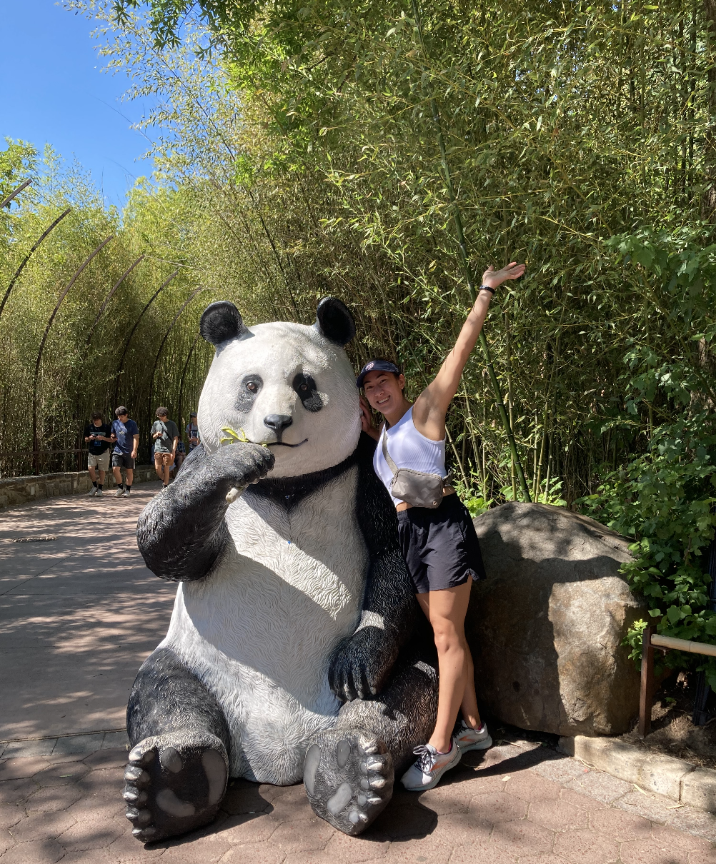 Noelle Harada poses with a statue of a panda at the zoo. 