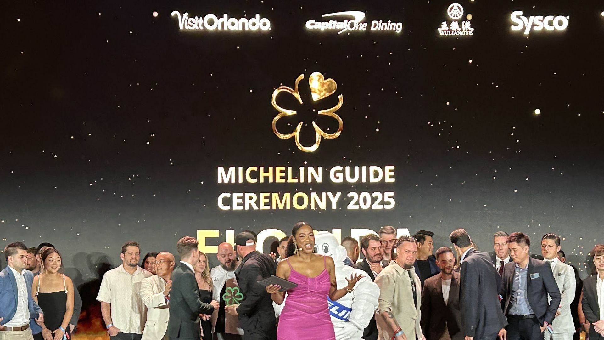 Chefs who were honored by the Michelin Guide celebrate on stage.