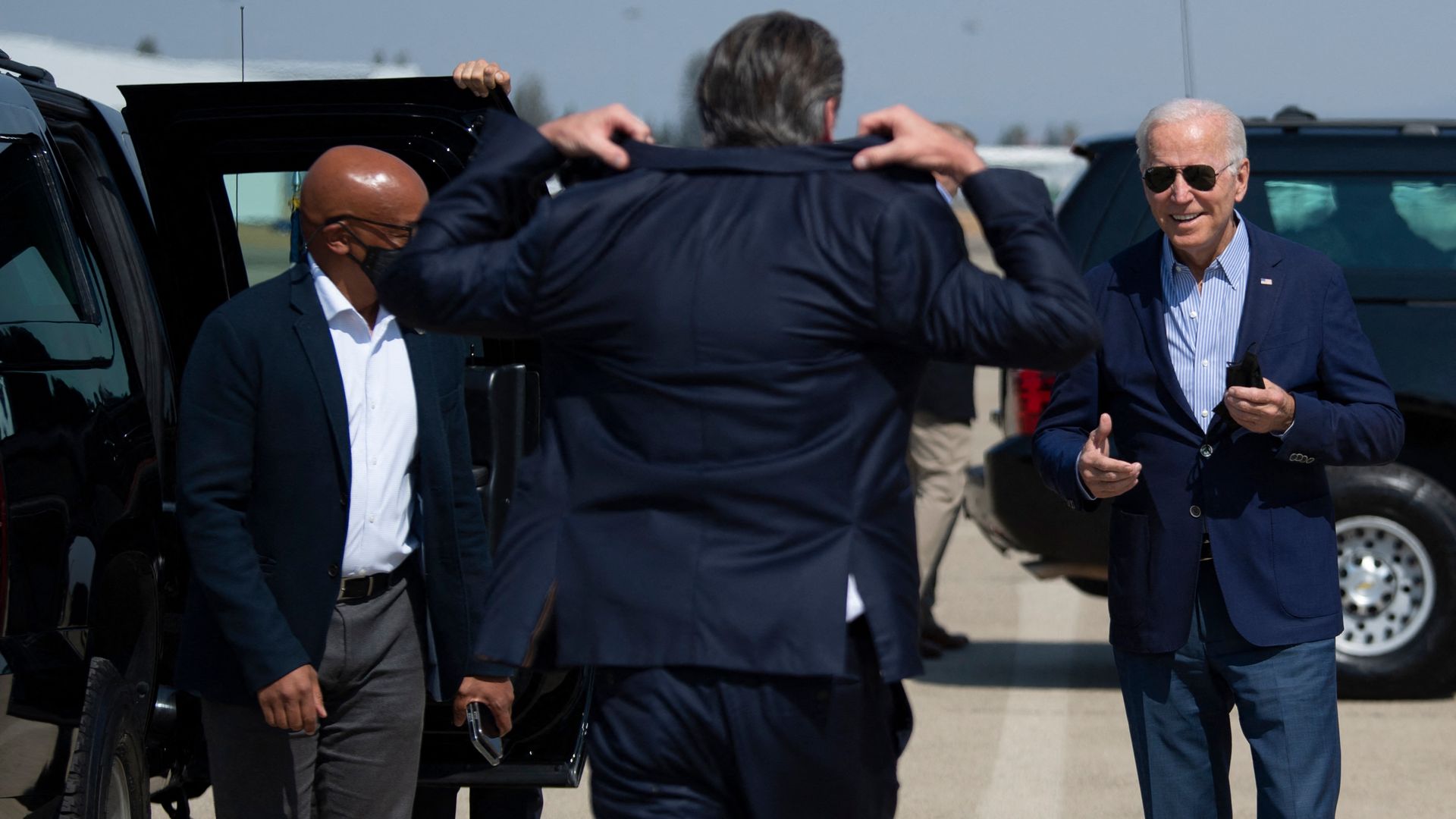 California Gov. Gavin Newsom is seen donning his sport jacket as President Biden arrives for a campaign stop.