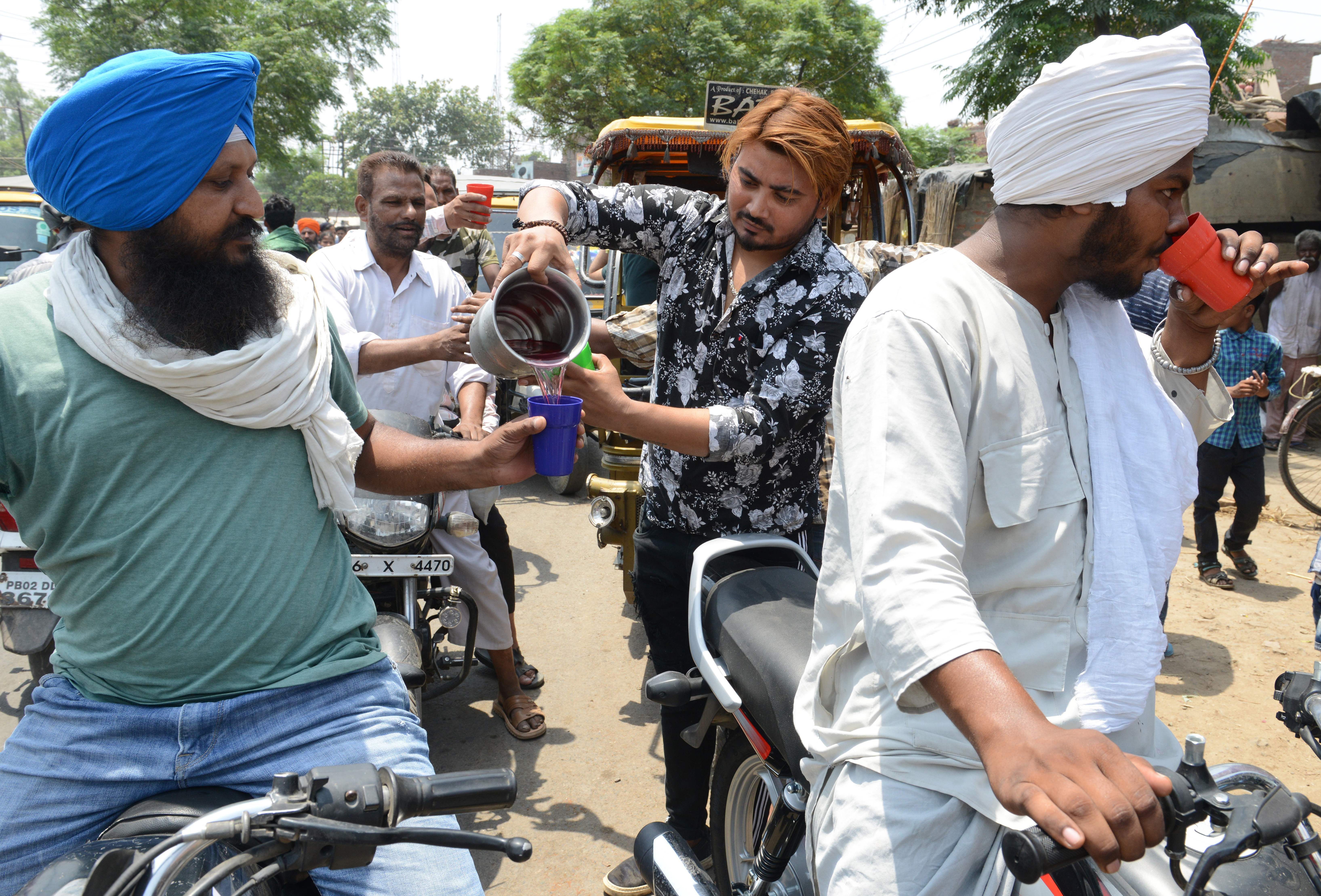 volunteers distribute sweet water during a hot summer day, in Amritsar on June 2, 2019.
