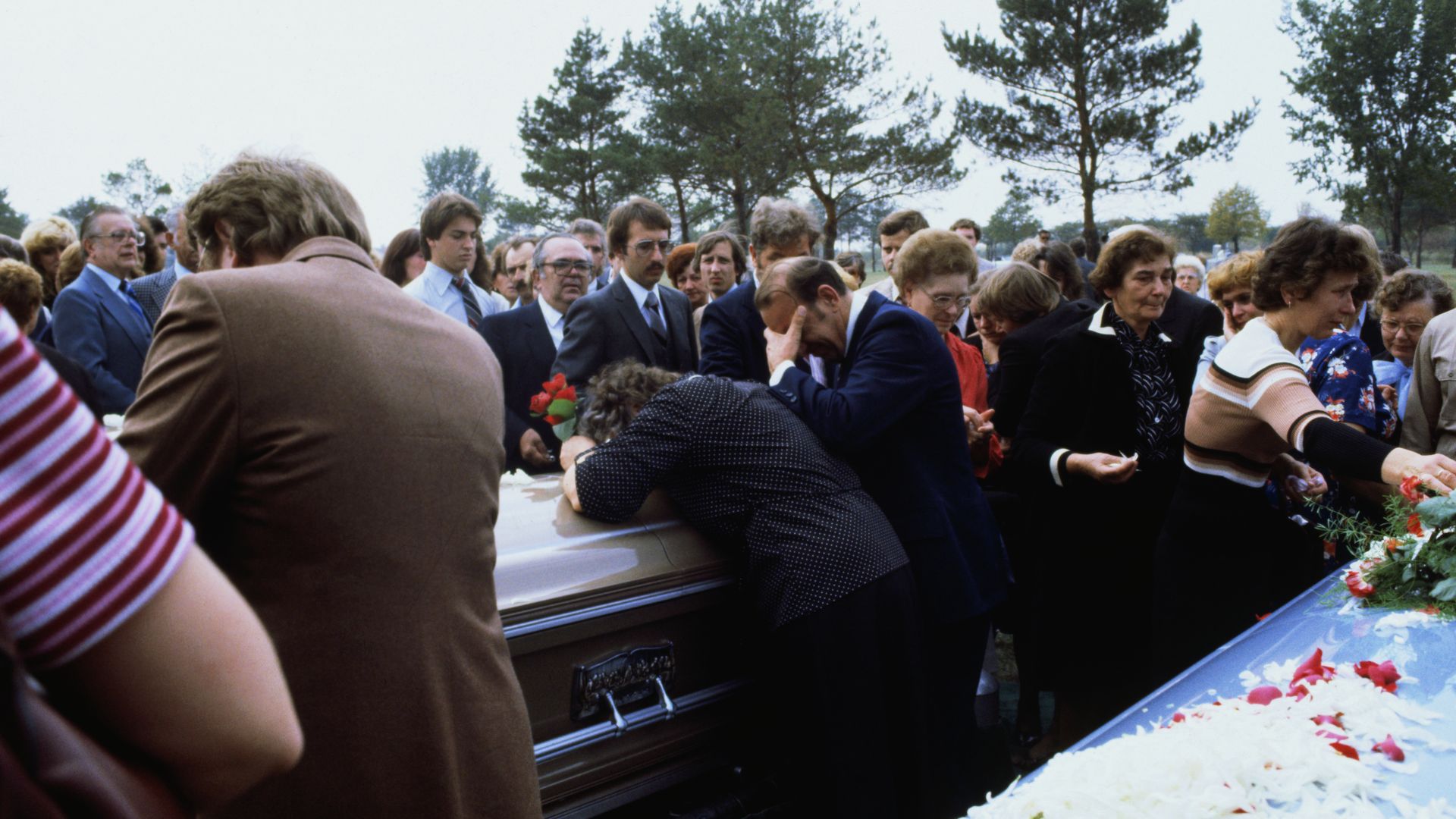 Photo of a grieving family at a funeral. 
