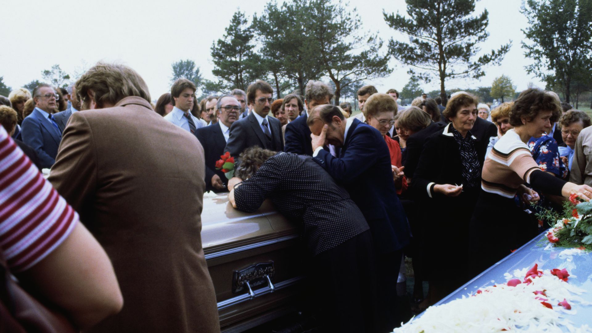 Photo of a grieving family at a funeral.