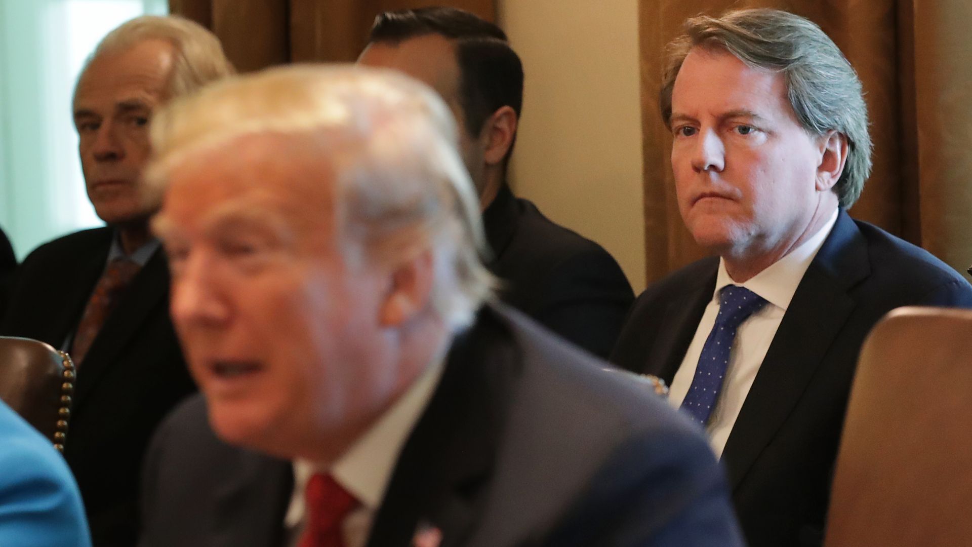 Don McGahn sits behind President Trump, both are wearing suits