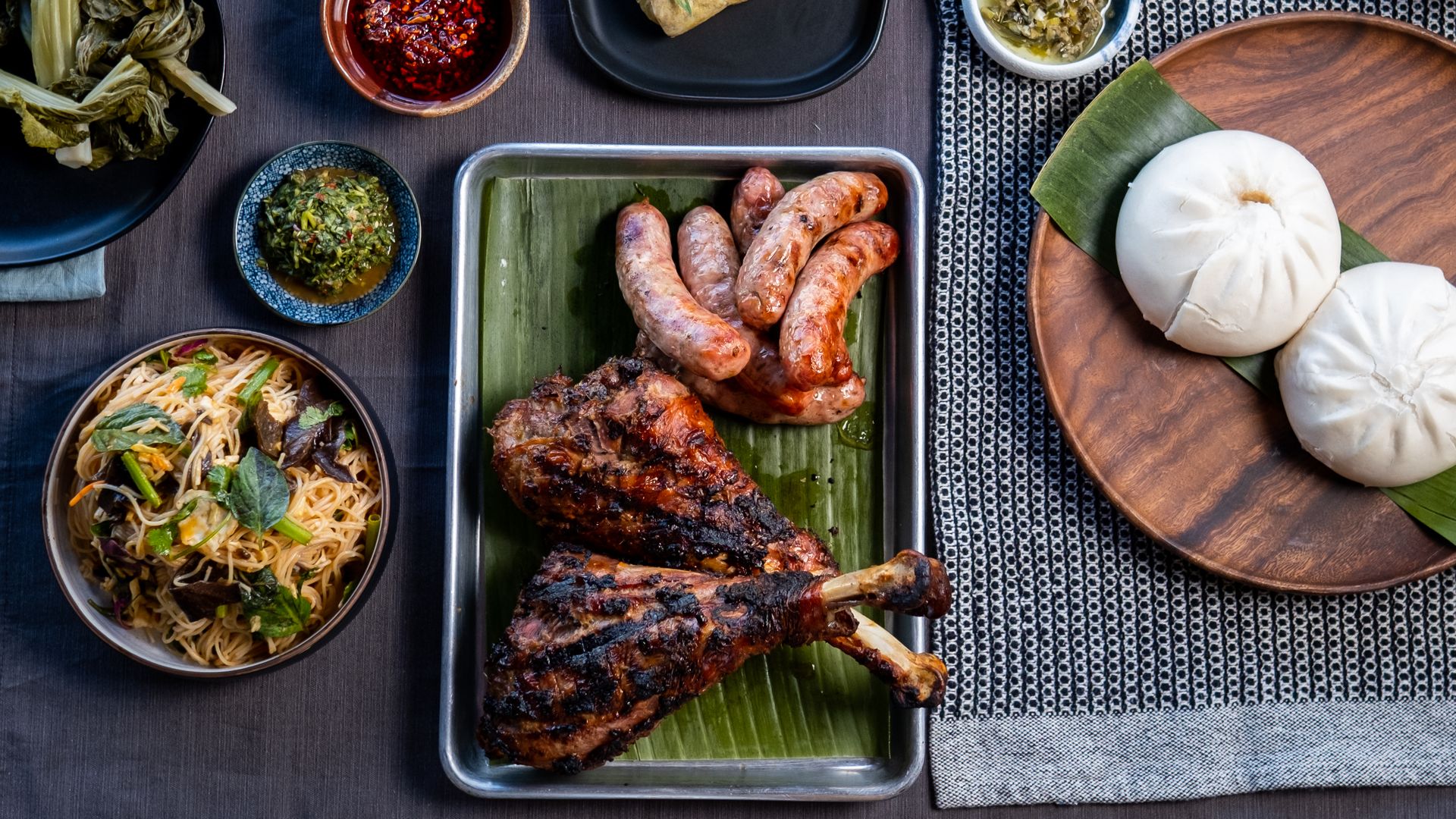 A platter of Hmong food, including turkey legs and steam buns.