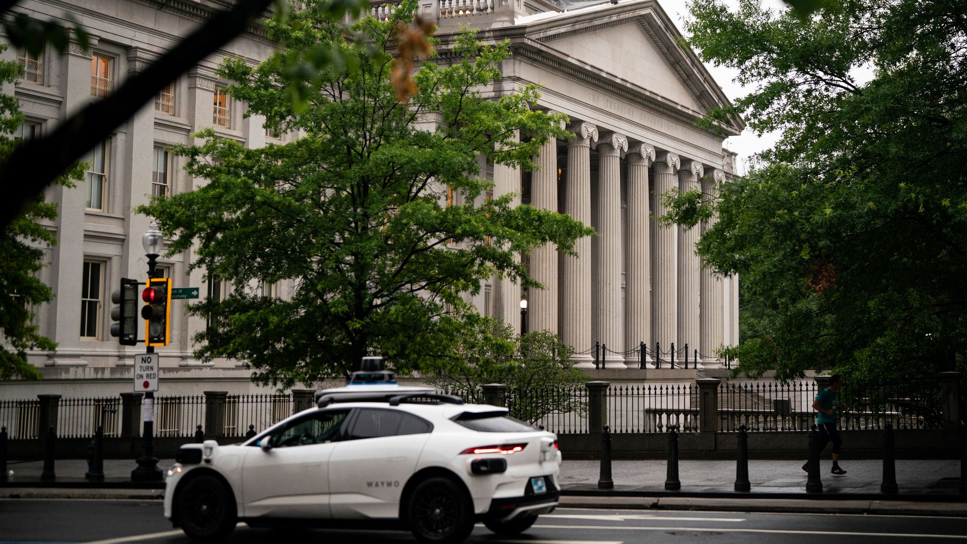A Waymo test vehicle drives on a road in downtown D.C.