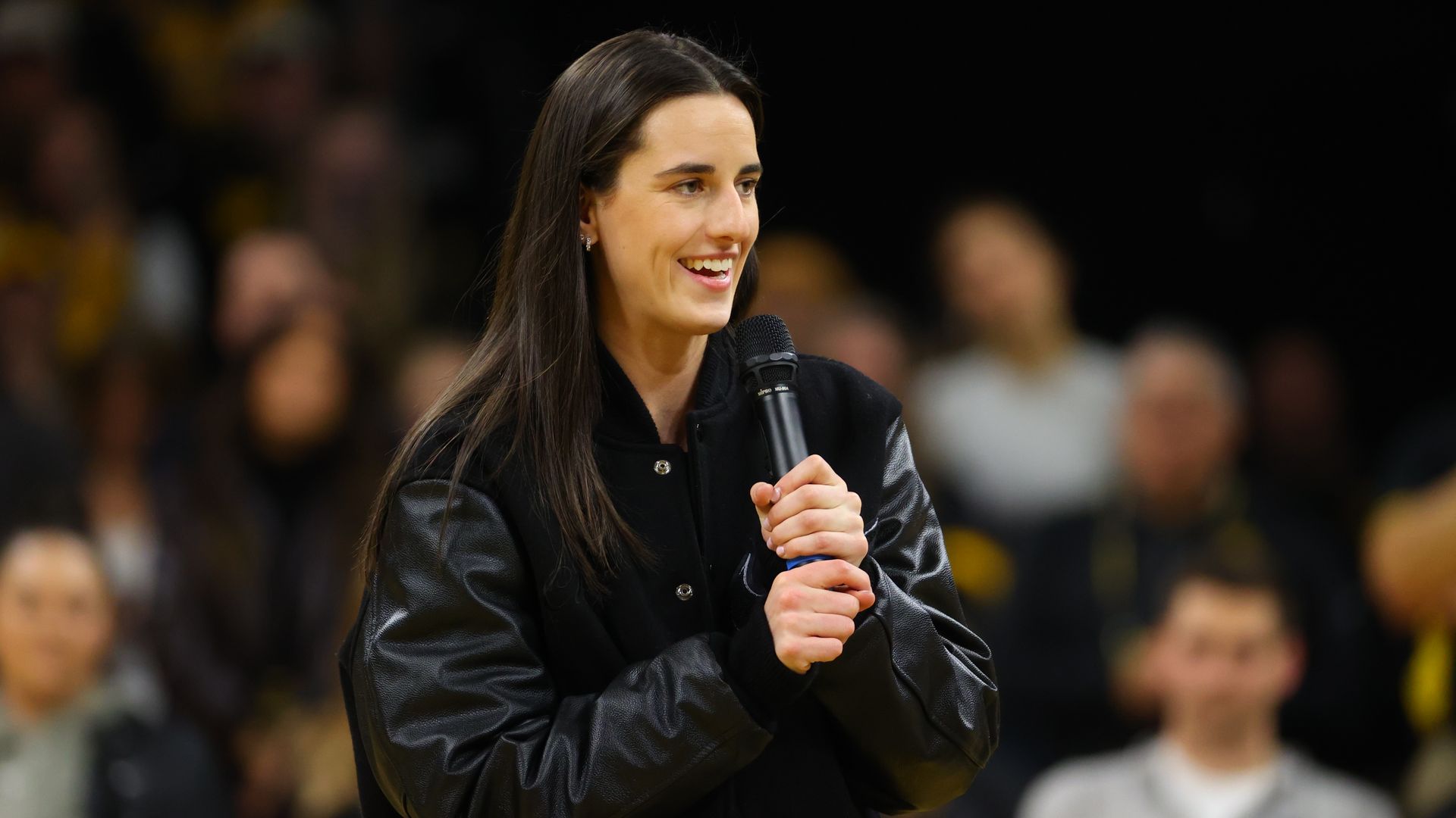 Caitlin Clark holding a microphone