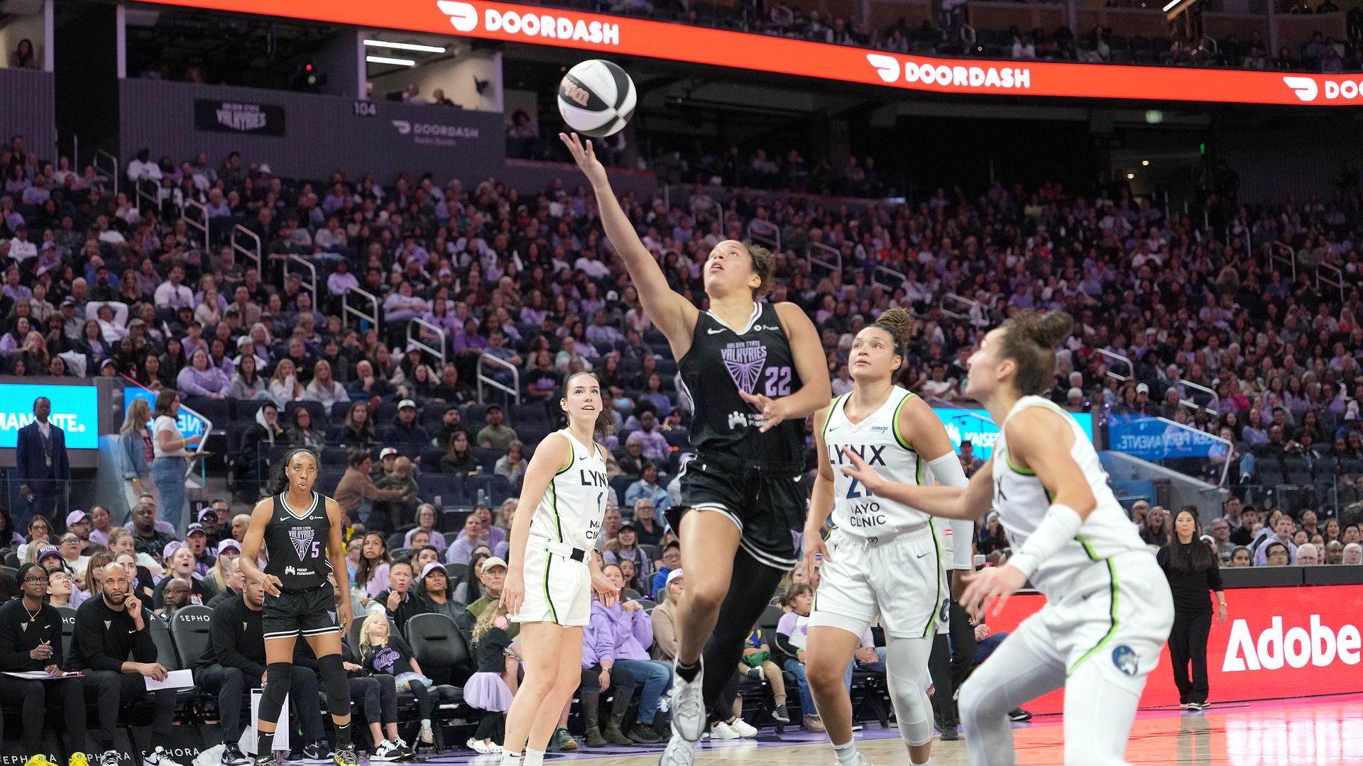 Photo of Veronica Burton laying up a basketball to the hoop while Lynx players watch from behind