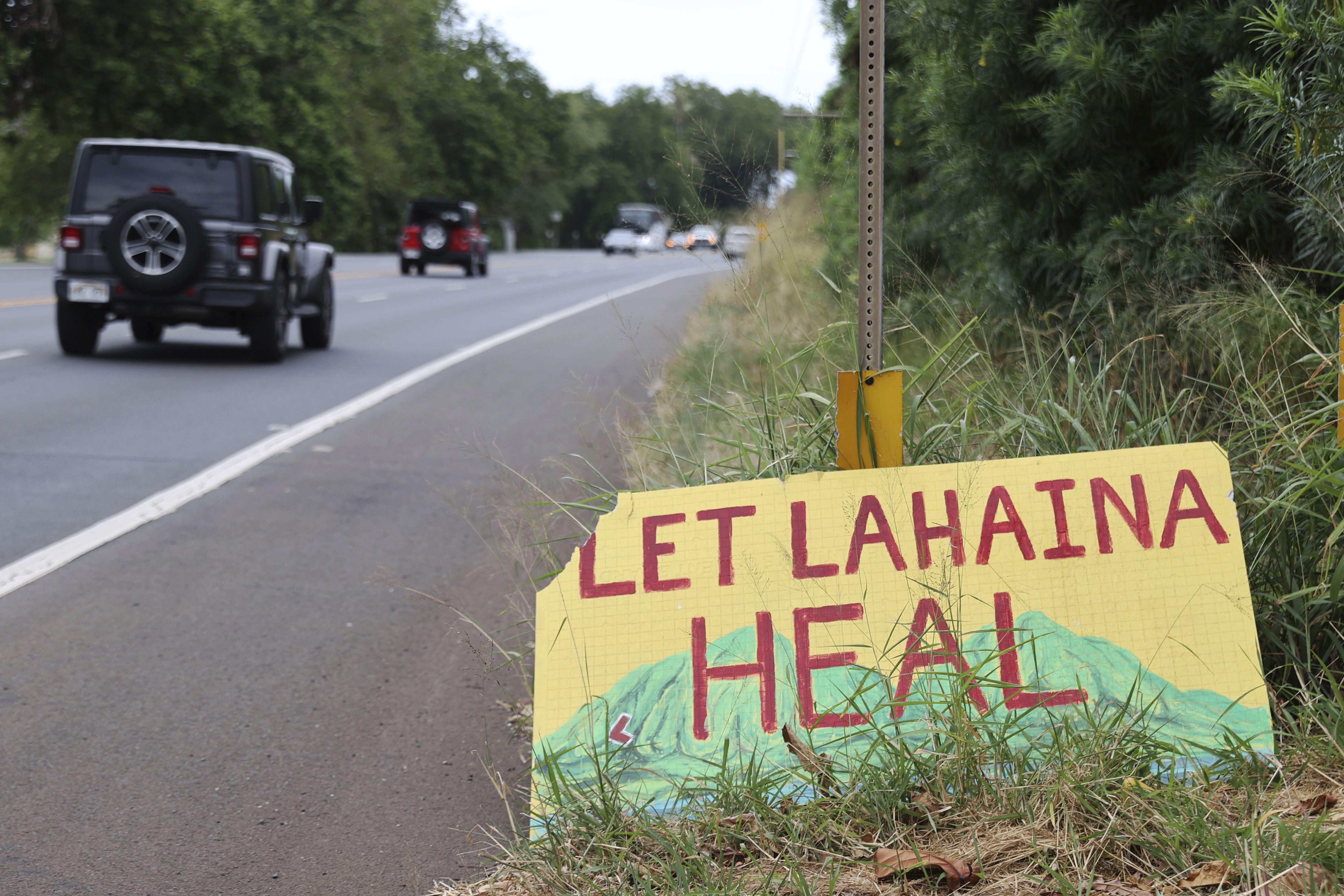 A sign stating "Let Lahaina Heal" is seen on the side of the highway in Kanapali, Hawai'i.