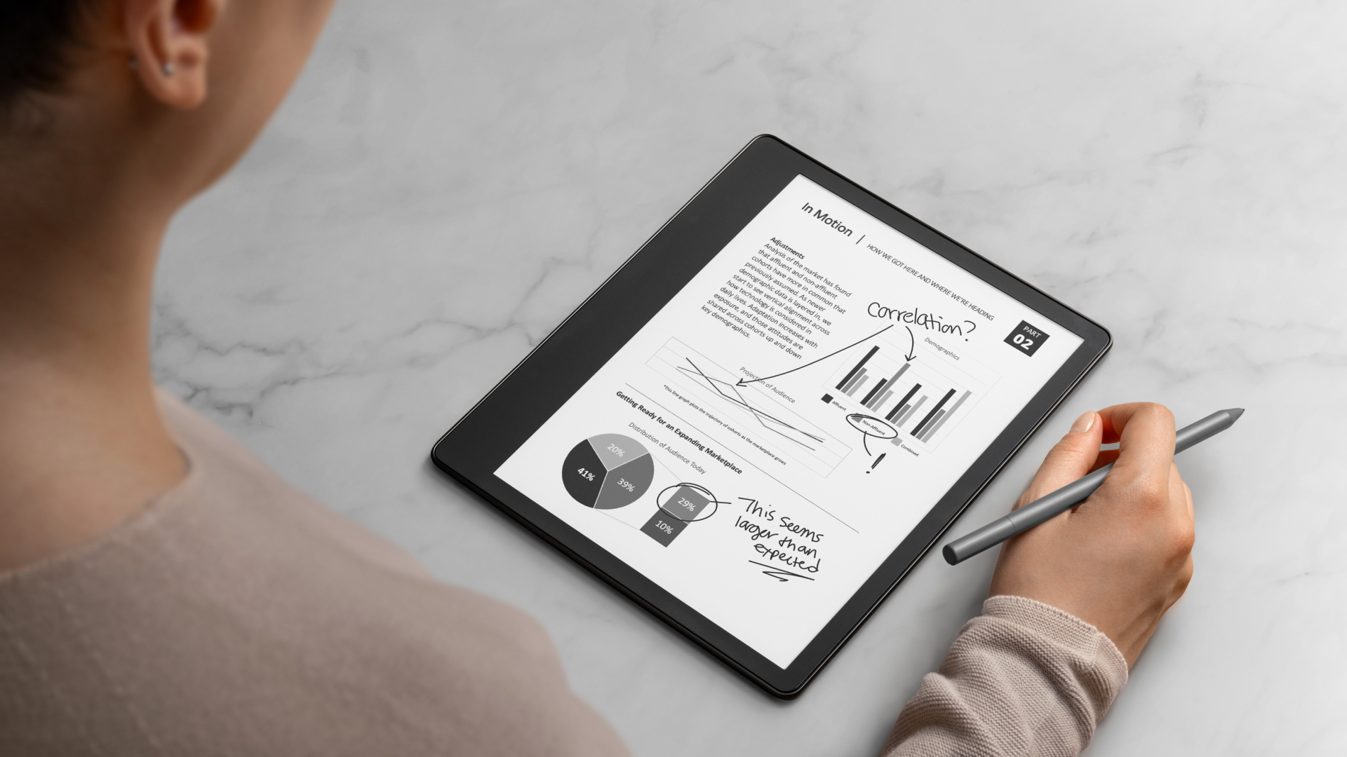 An image of a man next to a Kindle Scribe being used to mark up a PDF document 