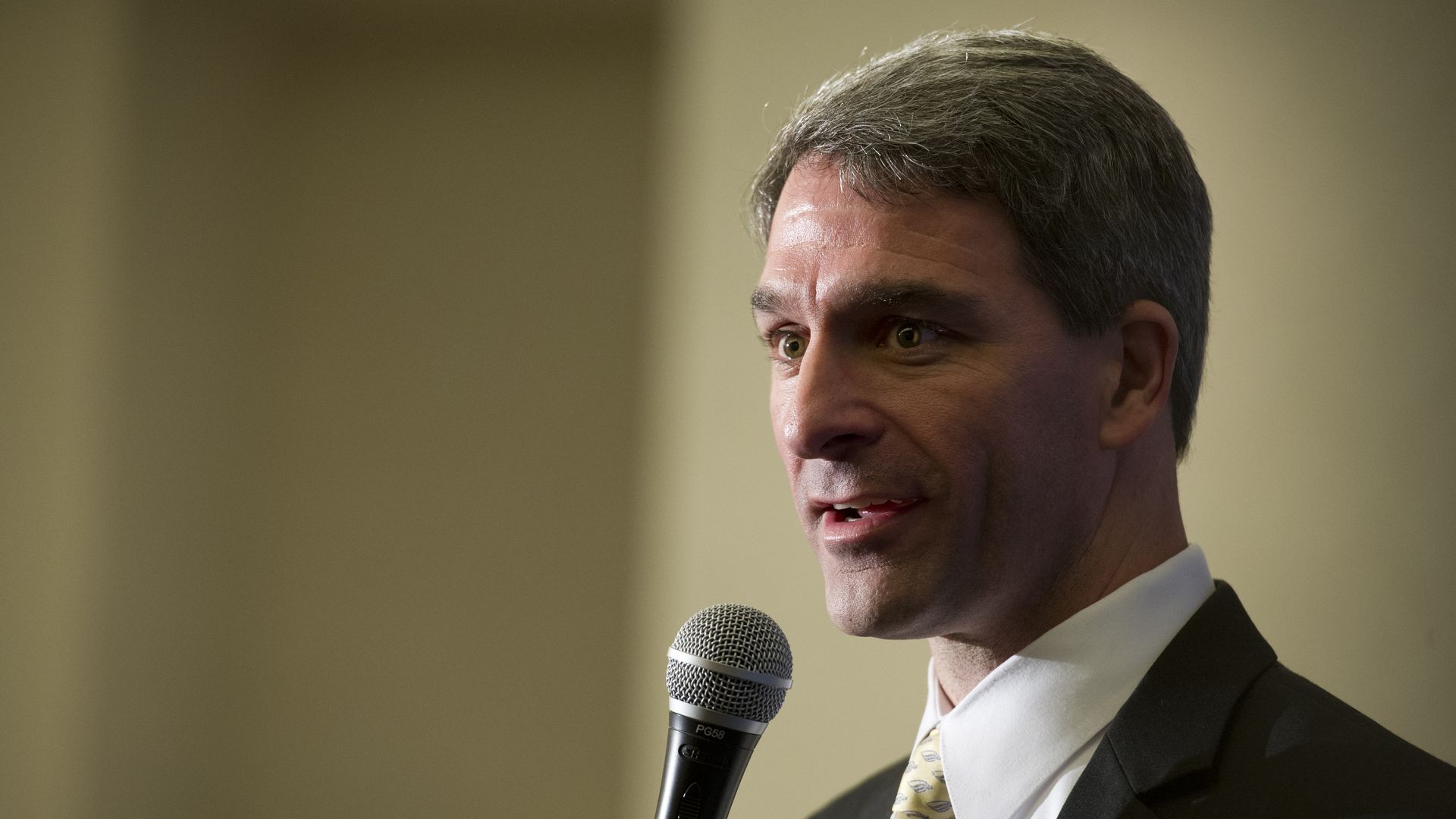 In this image, Kenneth speaks into a microphone.