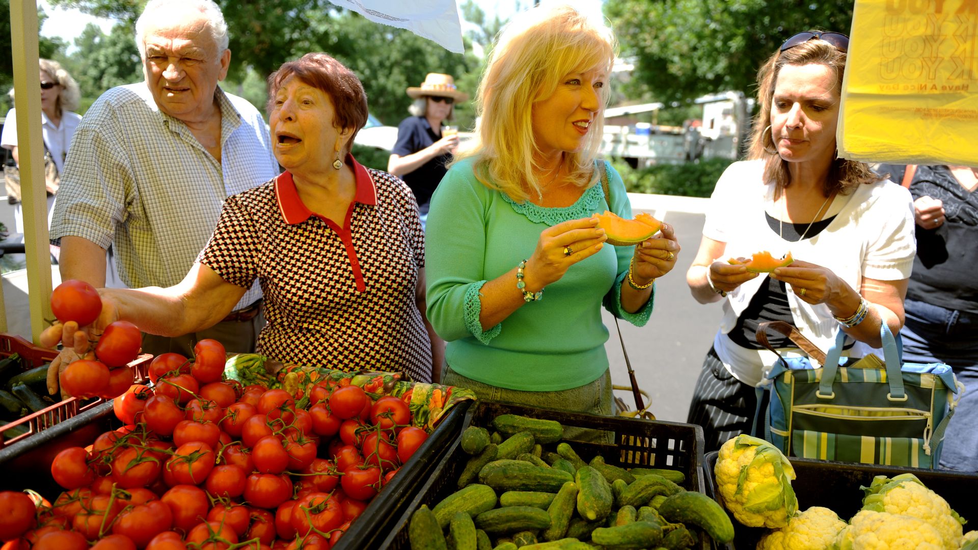 Tasting the fruits at the booth of Palizzi Farm at Cherry Creek Fresh Market.