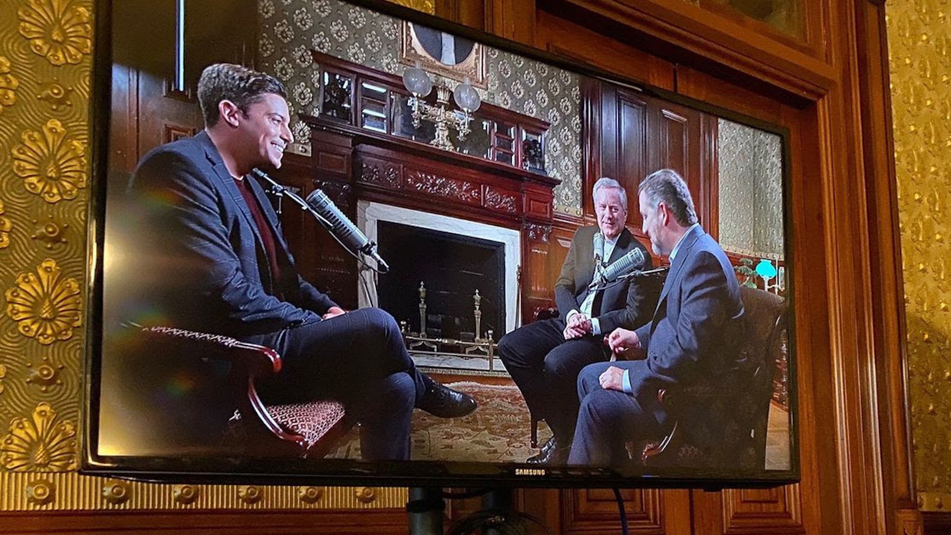 A monitor shows Ted Cruz interviewing Mark Meadows
