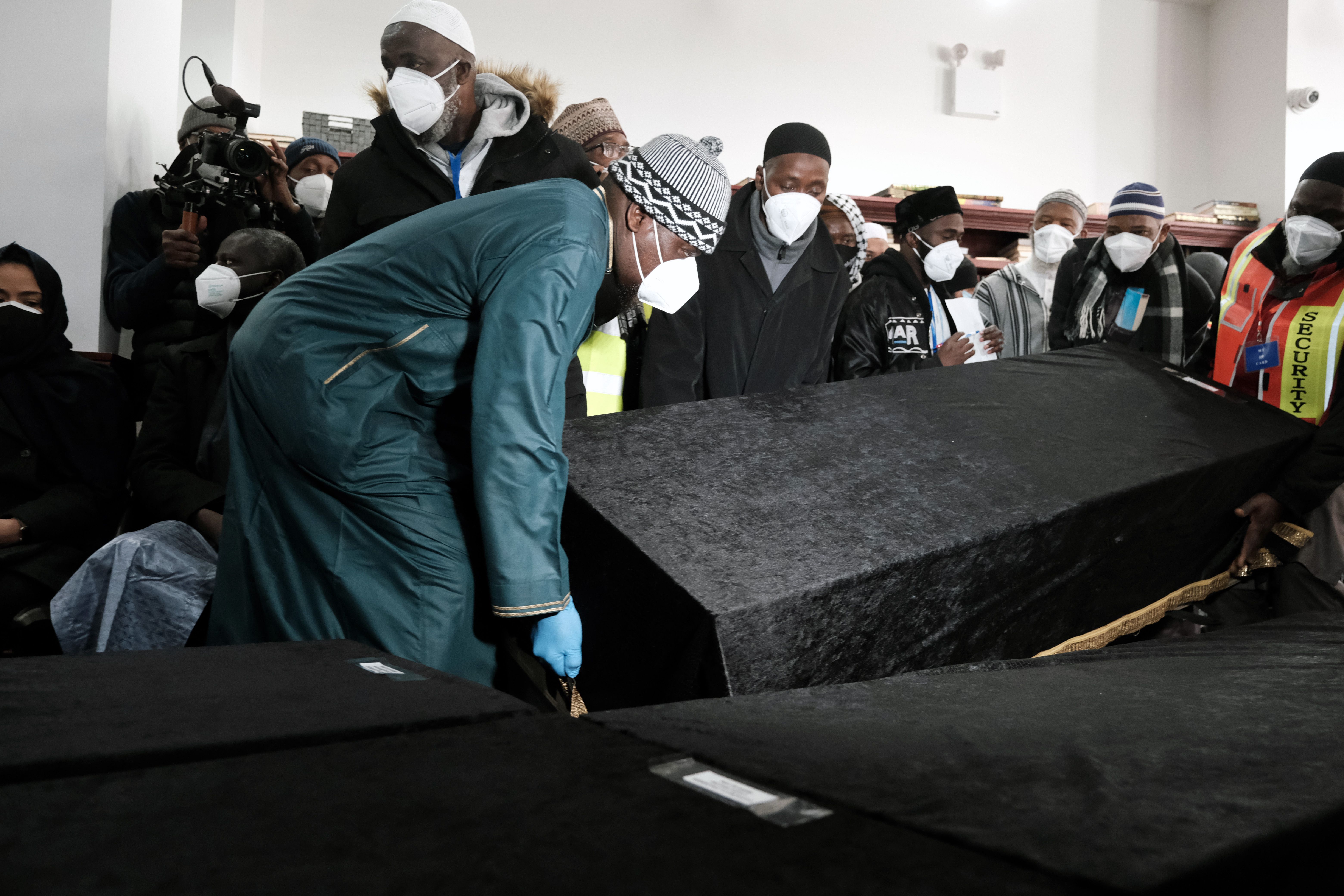 Caskets are brought into the Islamic Cultural Center for a mass funeral for 15